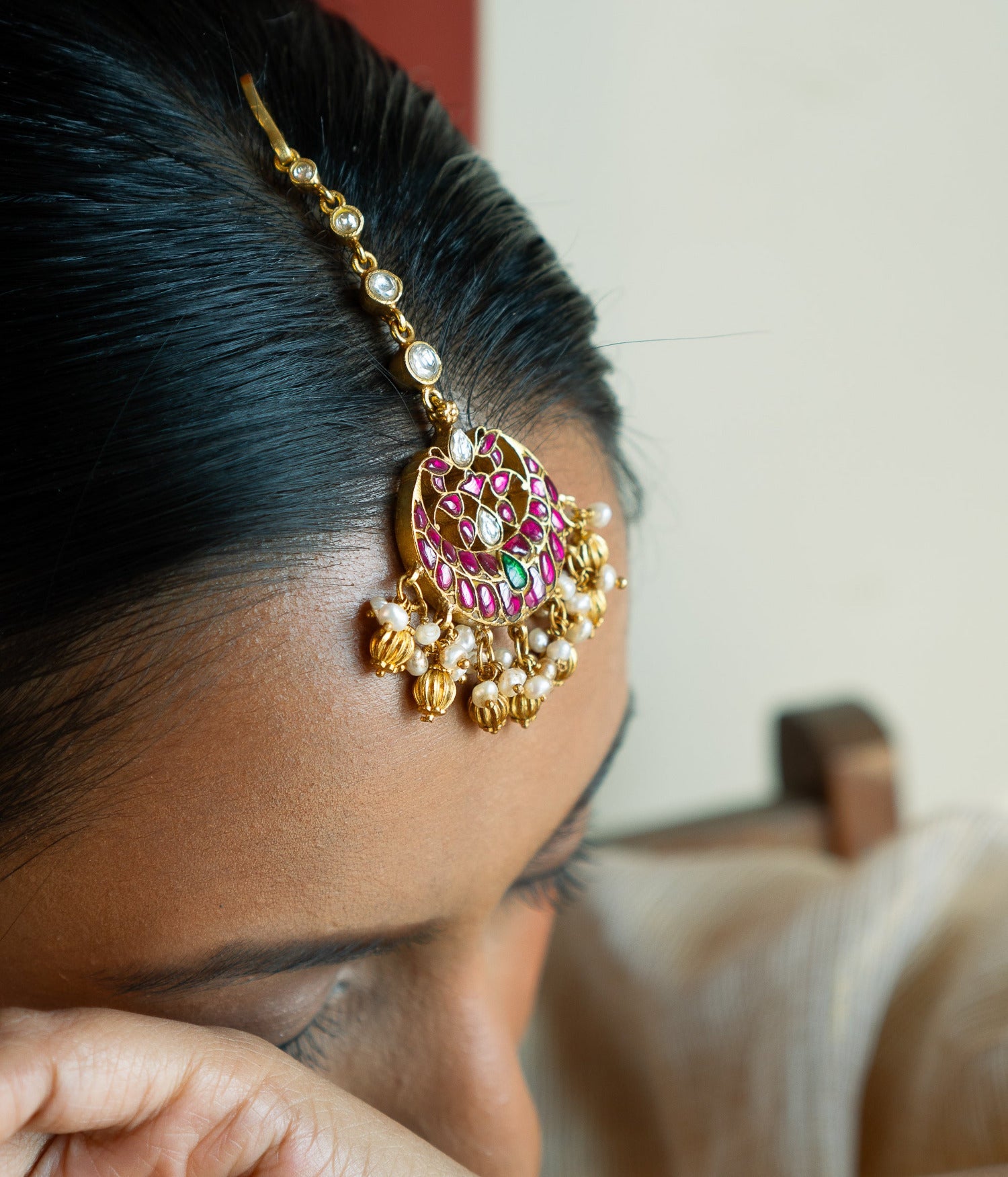 Traditional bridal maangtika with red and green Kundan stones