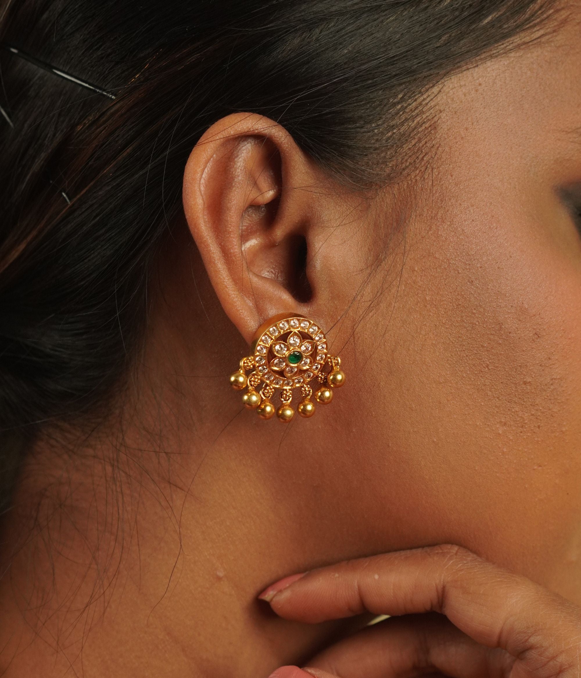 Indulge in luxury with Divasmantra's gold-plated drop earrings, featuring sparkling CZ stones and vibrant green cut stones—a perfect blend of timeless elegance and modern charm.