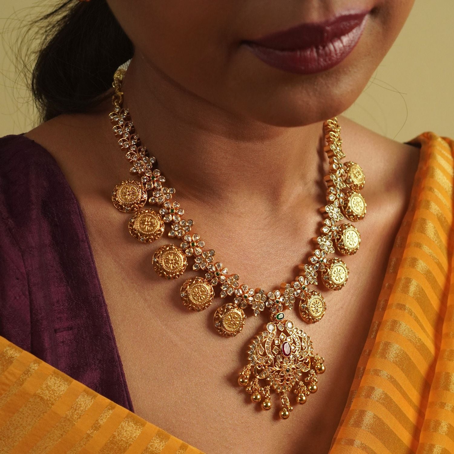Divasmantra's Chettinad-inspired necklace showcases a striking fusion of red and green cut stones with CZ accents, capturing the grandeur of heritage in a timeless design.