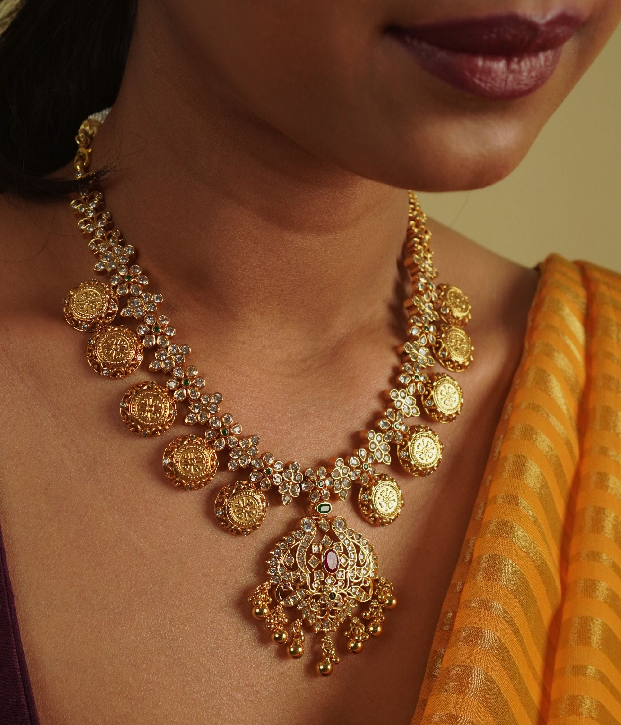 Divasmantra's Chettinad-inspired necklace showcases a striking fusion of red and green cut stones with CZ accents, capturing the grandeur of heritage in a timeless design.