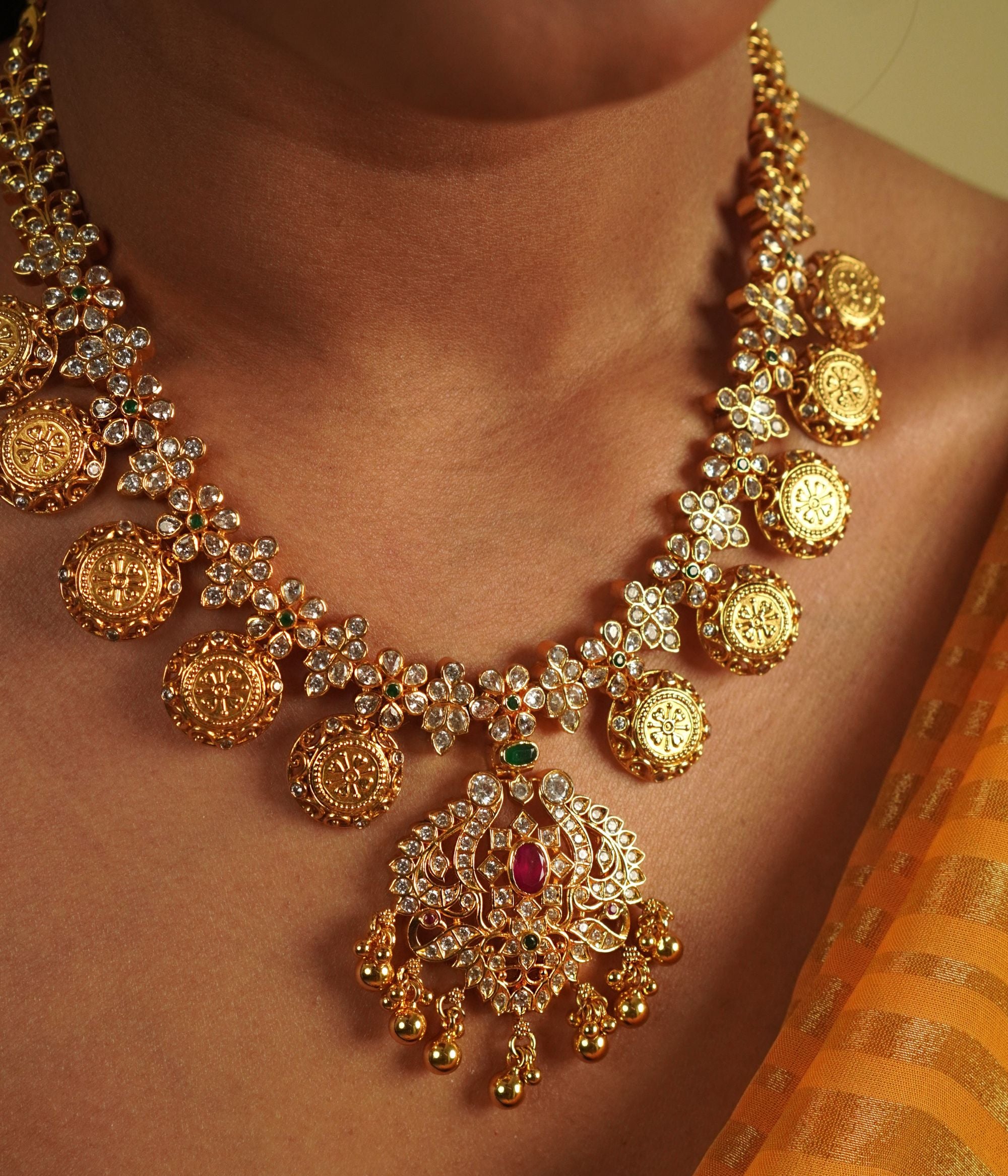 Divasmantra's Chettinad-inspired necklace showcases a striking fusion of red and green cut stones with CZ accents, capturing the grandeur of heritage in a timeless design.
