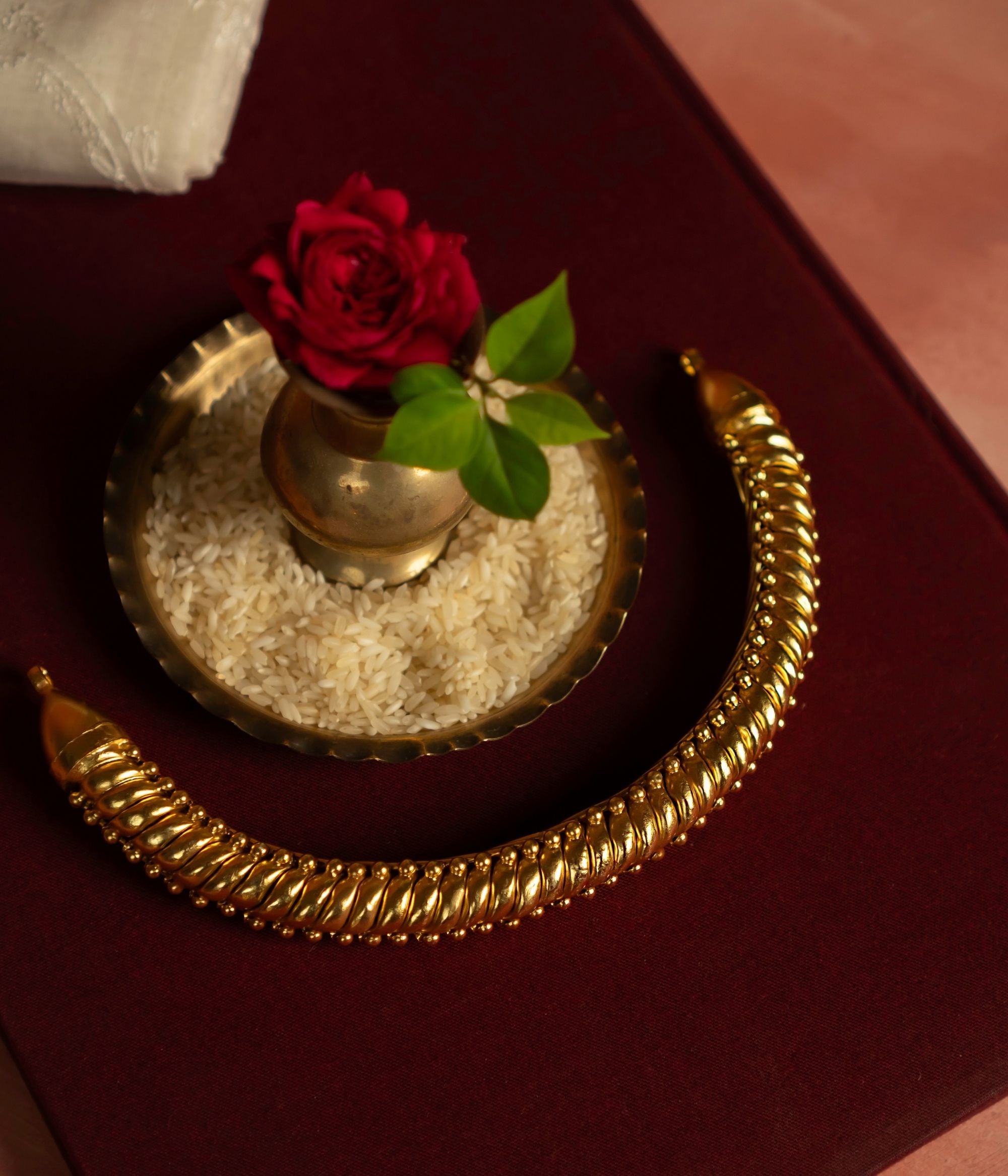 A beautifully crafted gold-plated silver jewellery piece, featuring a thick spiral-shaped chain that exudes elegance and tradition. This intricately designed chain is adorned with delicate golden beads at the ends, adding a touch of sophistication and charm. Its timeless design makes it a perfect accessory for both traditional and contemporary ensembles.
