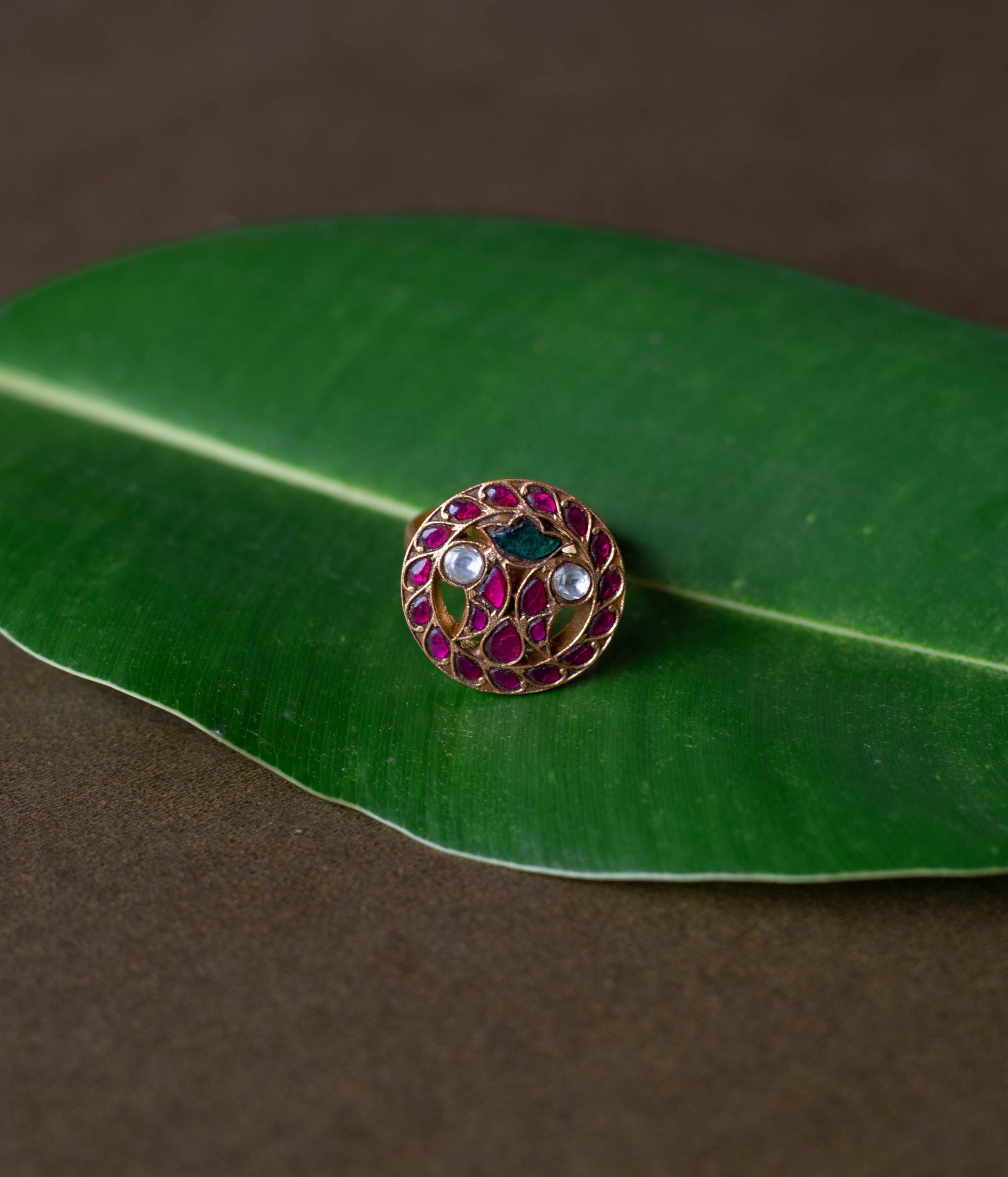 Kundan ring, Sparkling petals embrace a bird in a whisper of nature's grace.