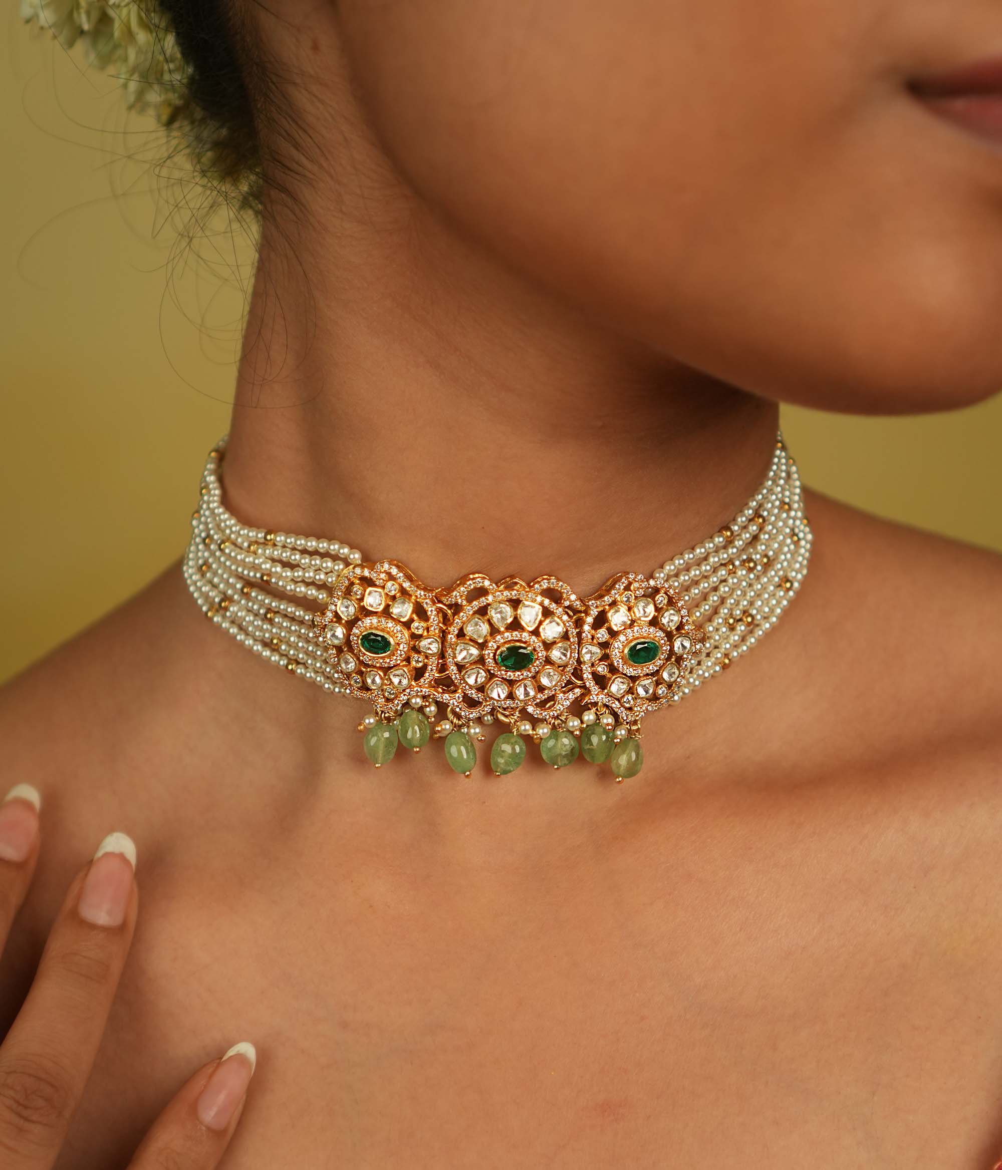Floral whispers come alive in this exquisite choker, featuring a delicate pearl chain, Moissanite Polki stones, CZ stones, green cut stones, green beads, and pearls. A celestial symphony of opulence and romance, this piece exudes timeless elegance, making it a perfect choice for the discerning connoisseur.