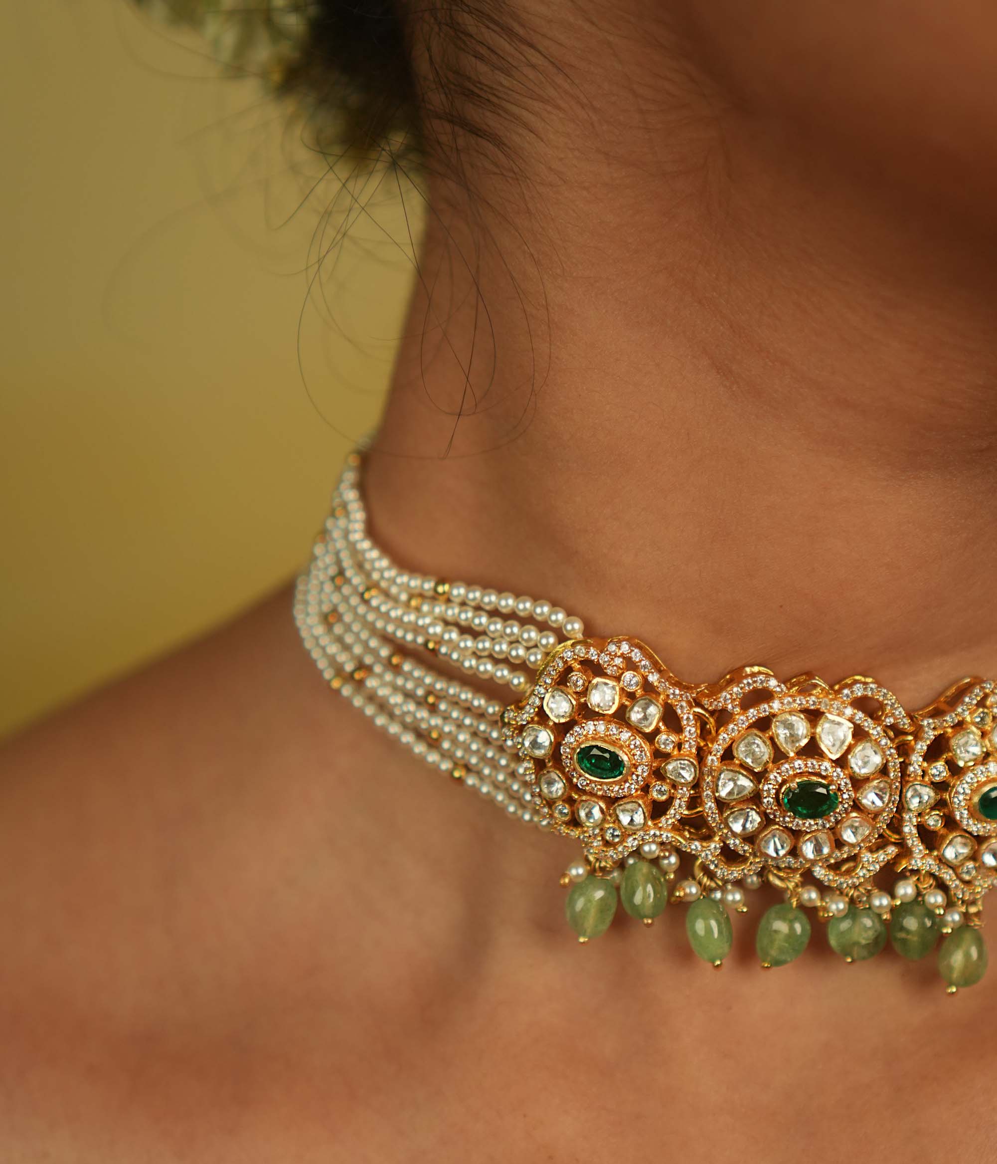 Floral whispers come alive in this exquisite choker, featuring a delicate pearl chain, Moissanite Polki stones, CZ stones, green cut stones, green beads, and pearls. A celestial symphony of opulence and romance, this piece exudes timeless elegance, making it a perfect choice for the discerning connoisseur.