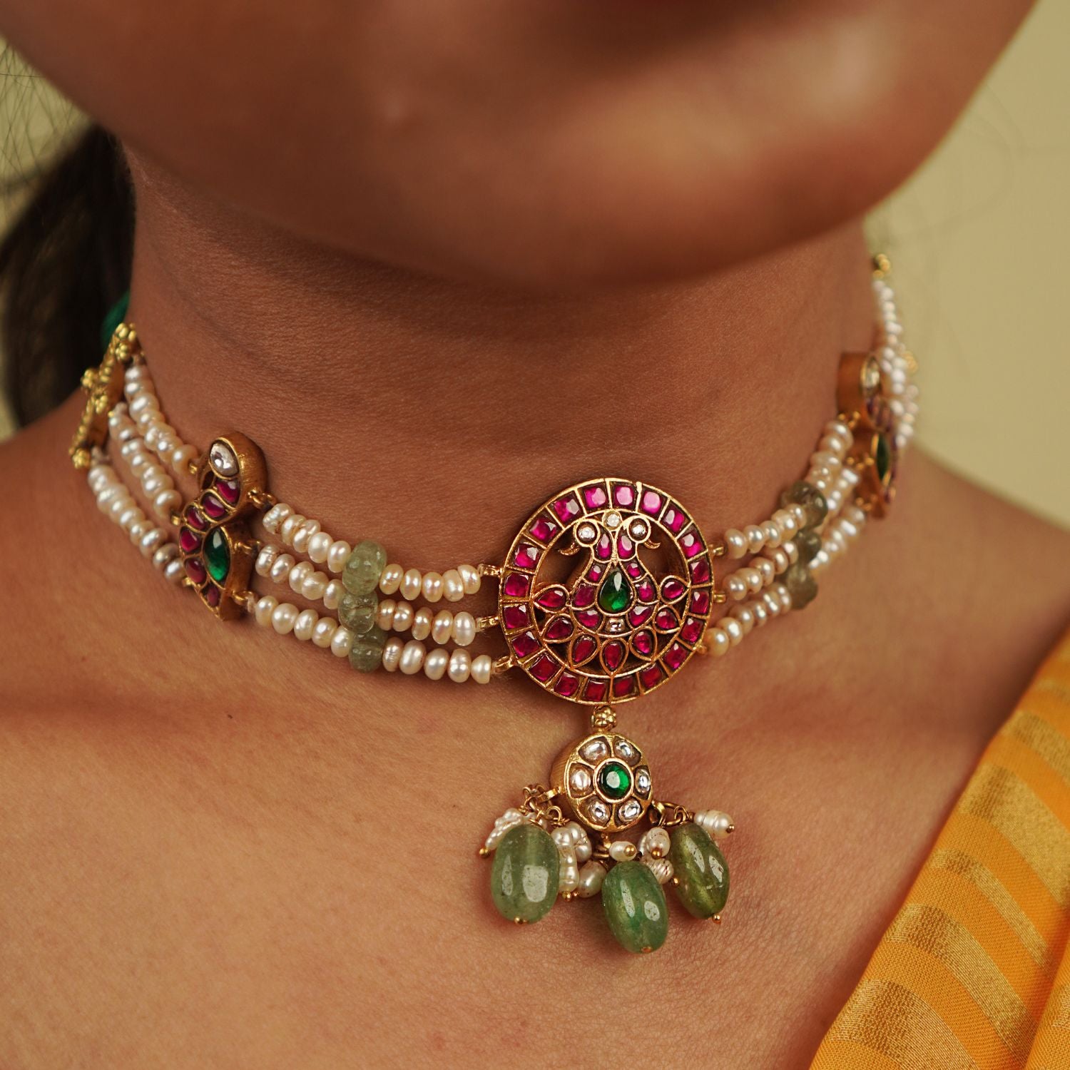Arunika Choker: A radiant tribute to Indian heritage, this necklace combines gold-plated silver, red, green, and white Kundan stones, green beads, and cultured pearls, celebrating the vibrancy of culture with timeless elegance.