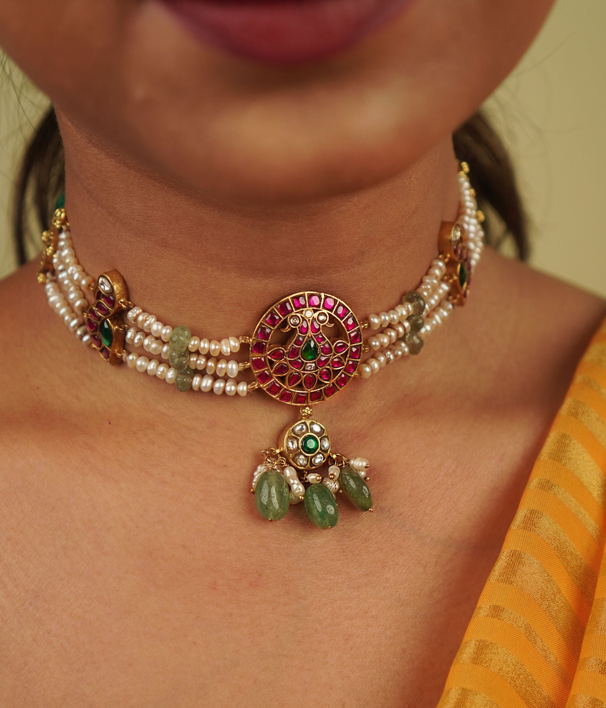 Arunika Choker: A radiant tribute to Indian heritage, this necklace combines gold-plated silver, red, green, and white Kundan stones, green beads, and cultured pearls, celebrating the vibrancy of culture with timeless elegance.