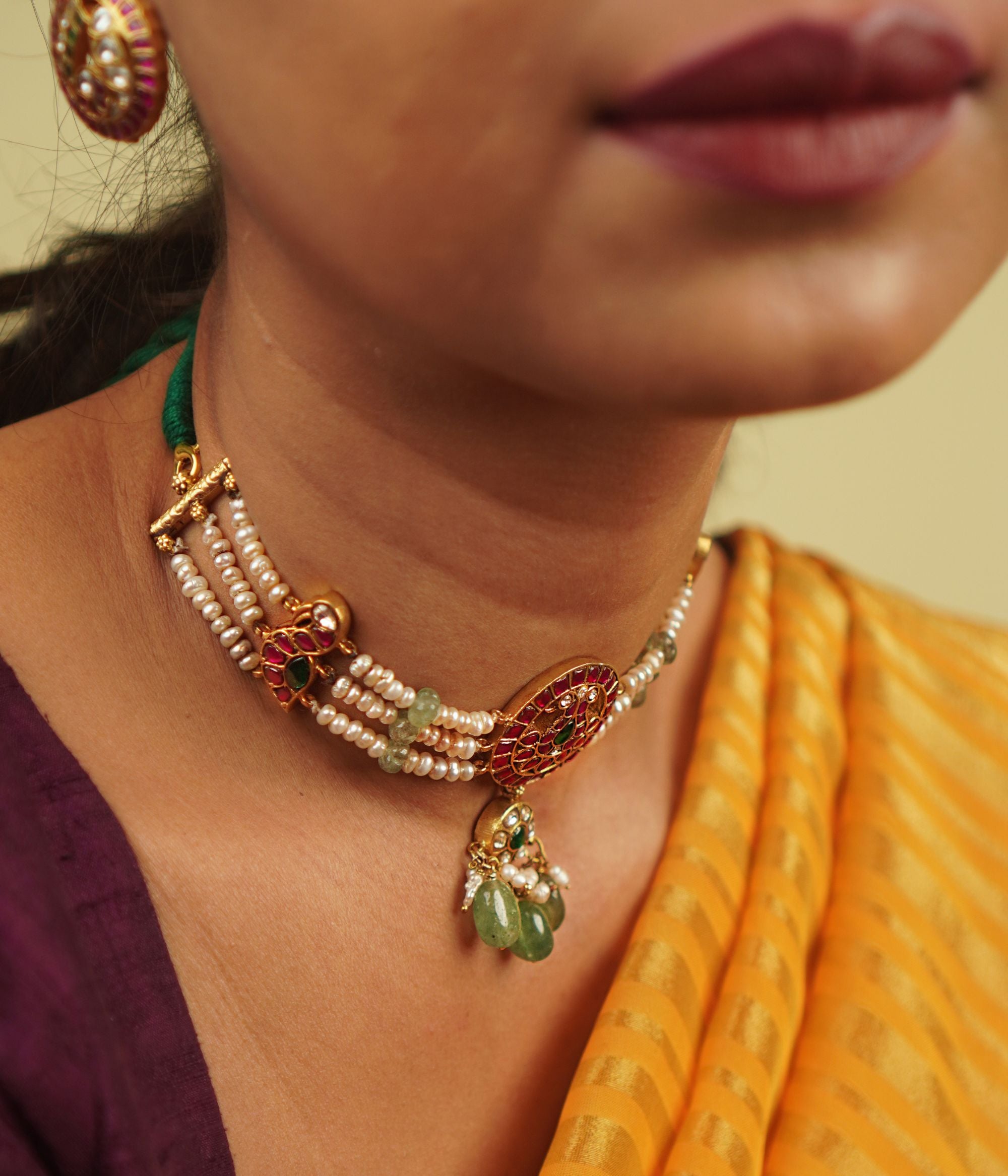 Arunika Choker: A radiant tribute to Indian heritage, this necklace combines gold-plated silver, red, green, and white Kundan stones, green beads, and cultured pearls, celebrating the vibrancy of culture with timeless elegance.