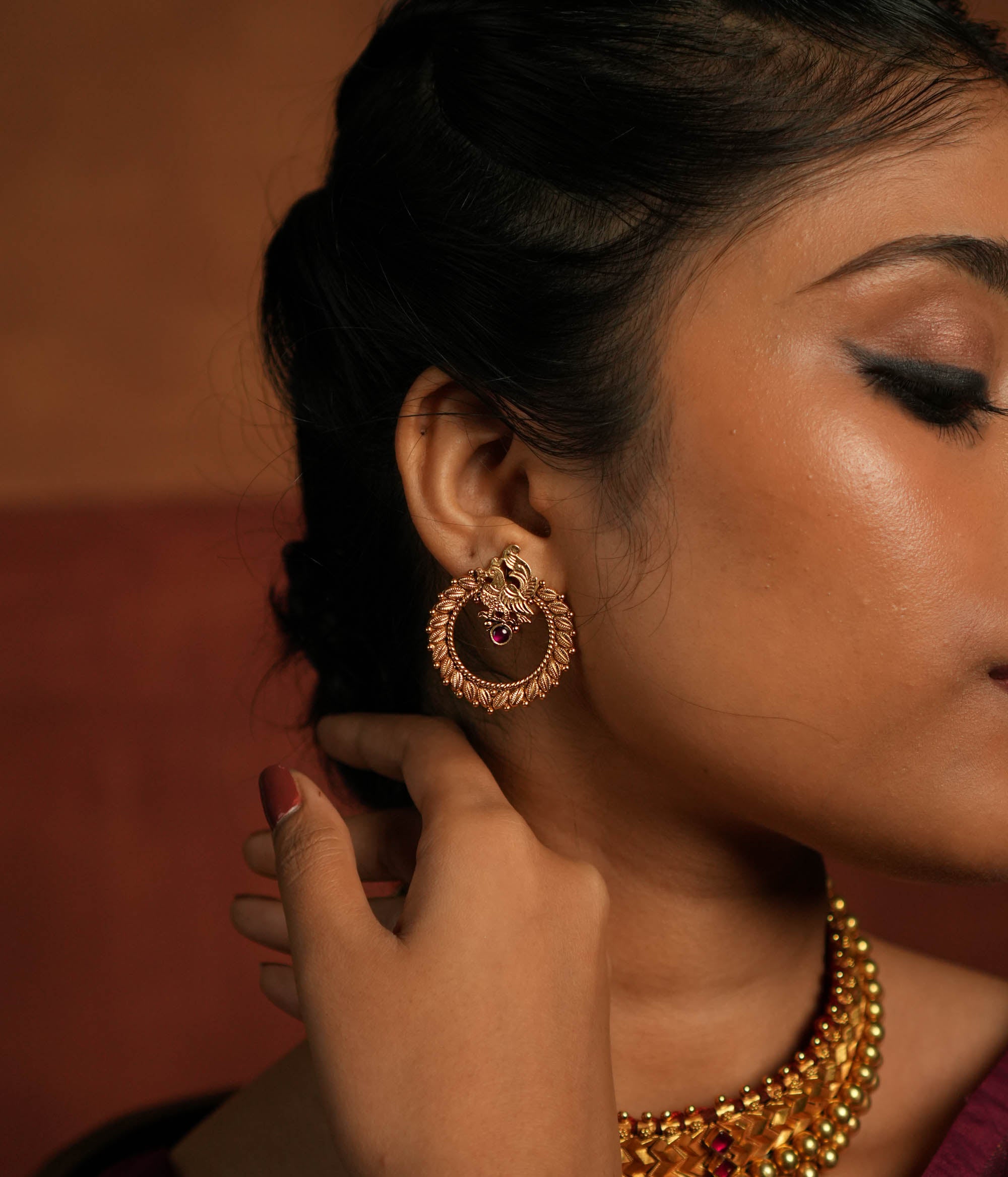 Close-up of handcrafted Avery earrings with red stones