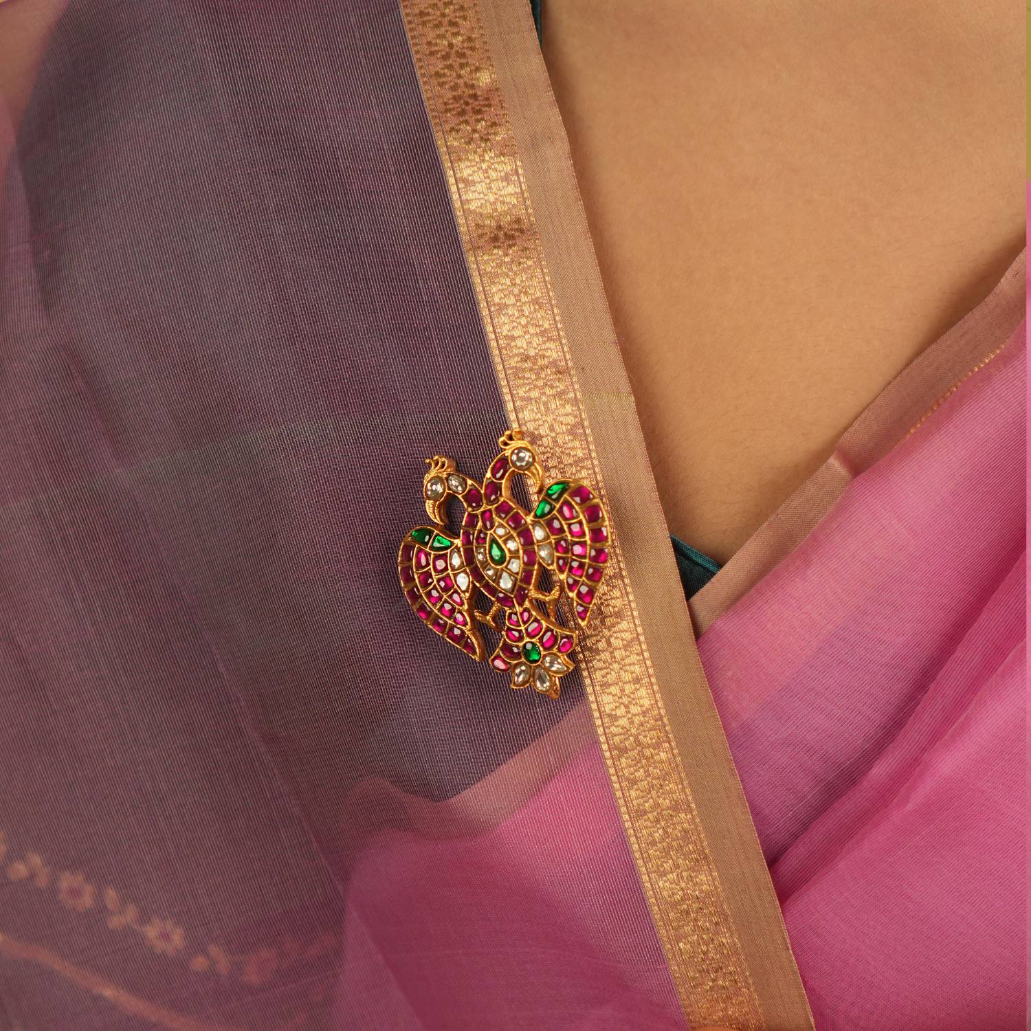 Adorned with red, green, and white Kundan stones, this brooch captivates with its intricate design and radiant hues, exuding timeless charm.