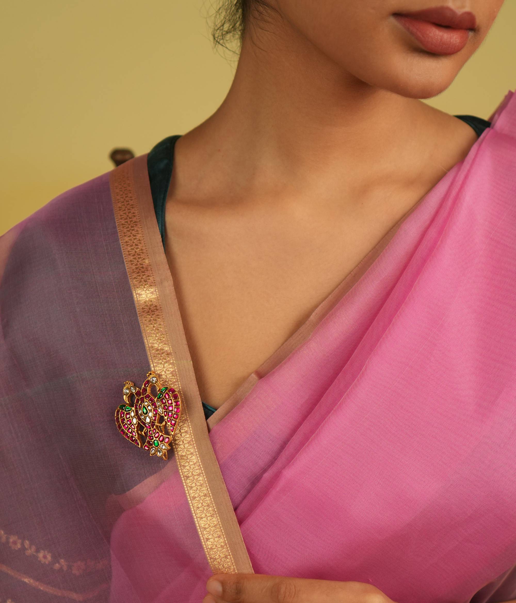 Adorned with red, green, and white Kundan stones, this brooch captivates with its intricate design and radiant hues, exuding timeless charm.
