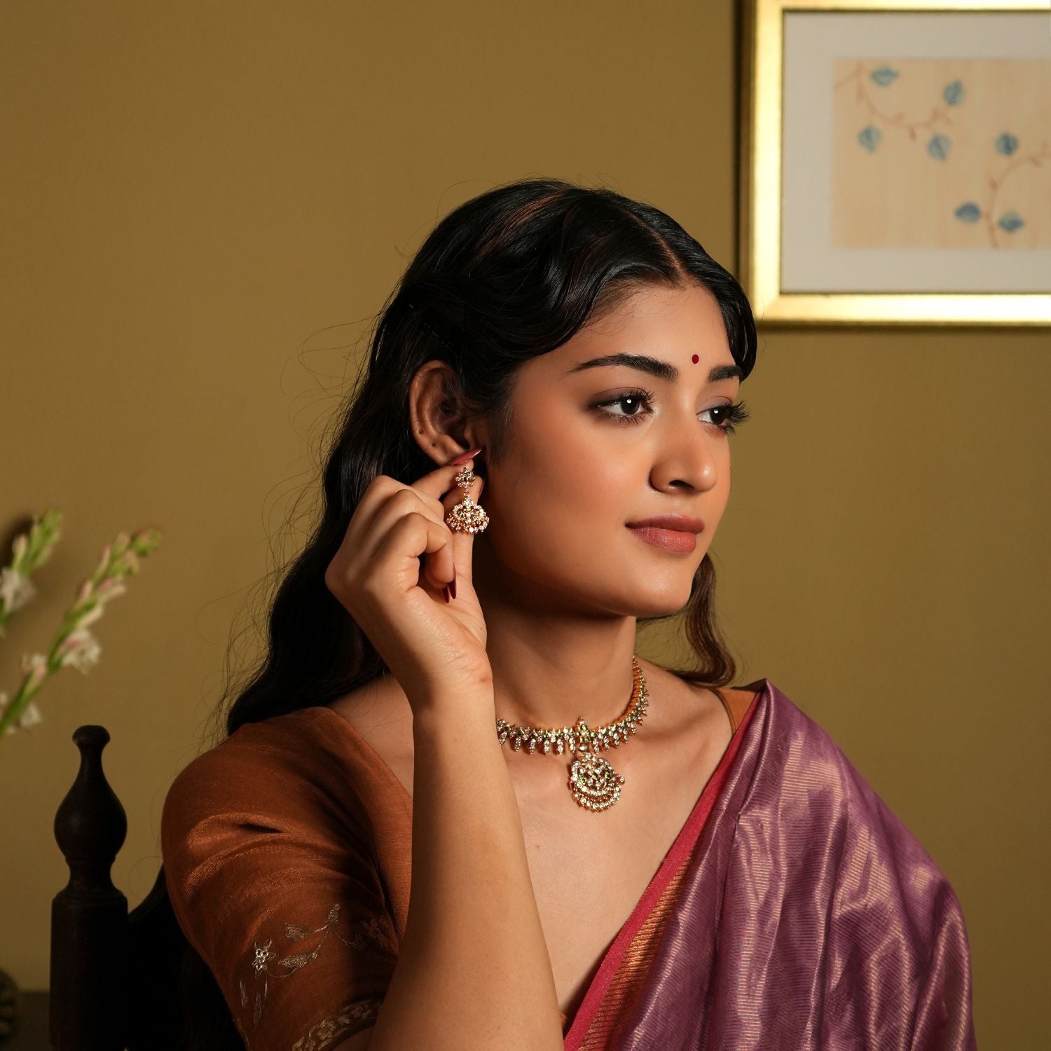 showcasing jewelry that appears to be made of 92.5 silver and adorned with Swarovski stones. The jewelry, including earrings and a necklace, seems to have a gold-plated finish, giving it a rich, elegant look.