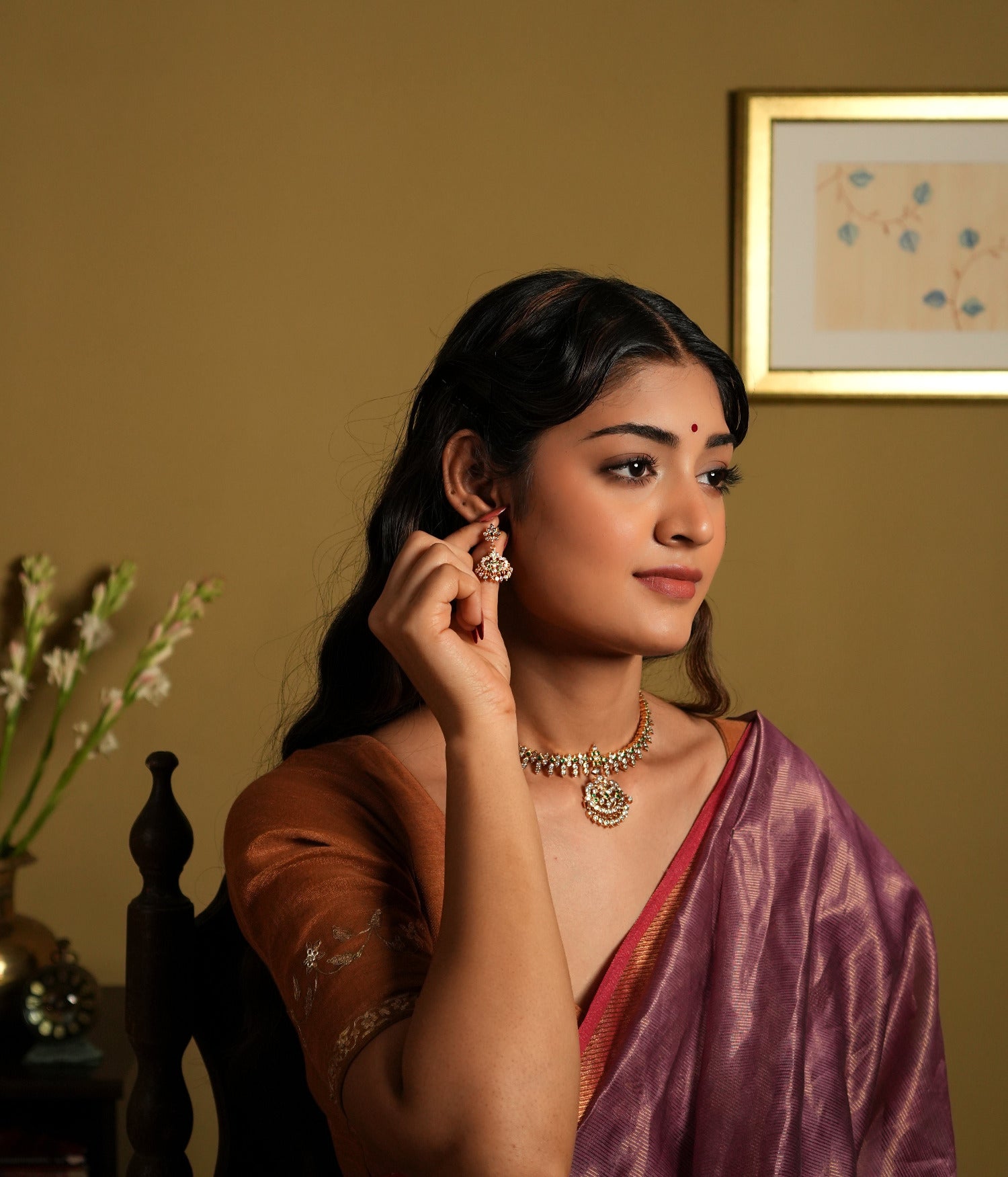 showcasing jewelry that appears to be made of 92.5 silver and adorned with Swarovski stones. The jewelry, including earrings and a necklace, seems to have a gold-plated finish, giving it a rich, elegant look.