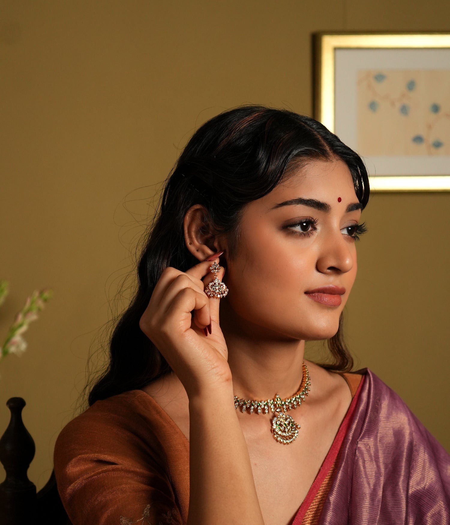 showcasing jewelry that appears to be made of 92.5 silver and adorned with Swarovski stones. The jewelry, including earrings and a necklace, seems to have a gold-plated finish, giving it a rich, elegant look.