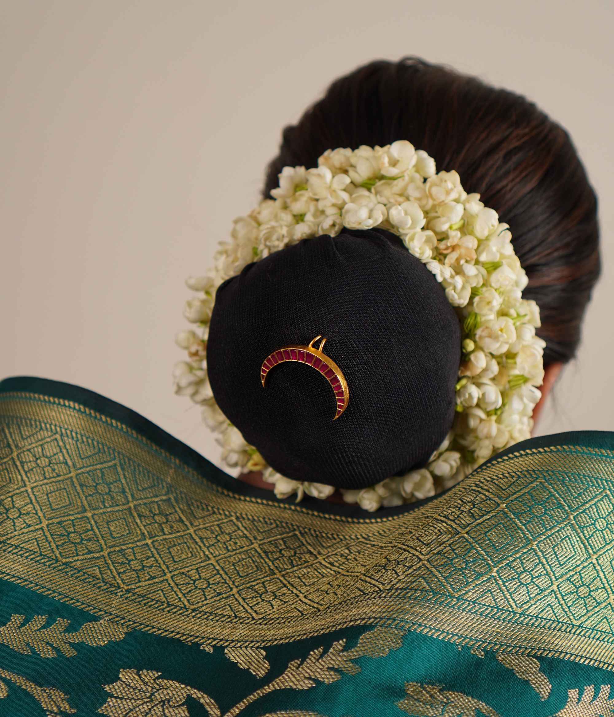 The Chandra hairpin, designed in an antique gold-plated silver finish, showcases a graceful moon-shaped silhouette adorned with radiant red kundan stones. A perfect fusion of heritage and contemporary elegance, each piece is meticulously handcrafted with care.