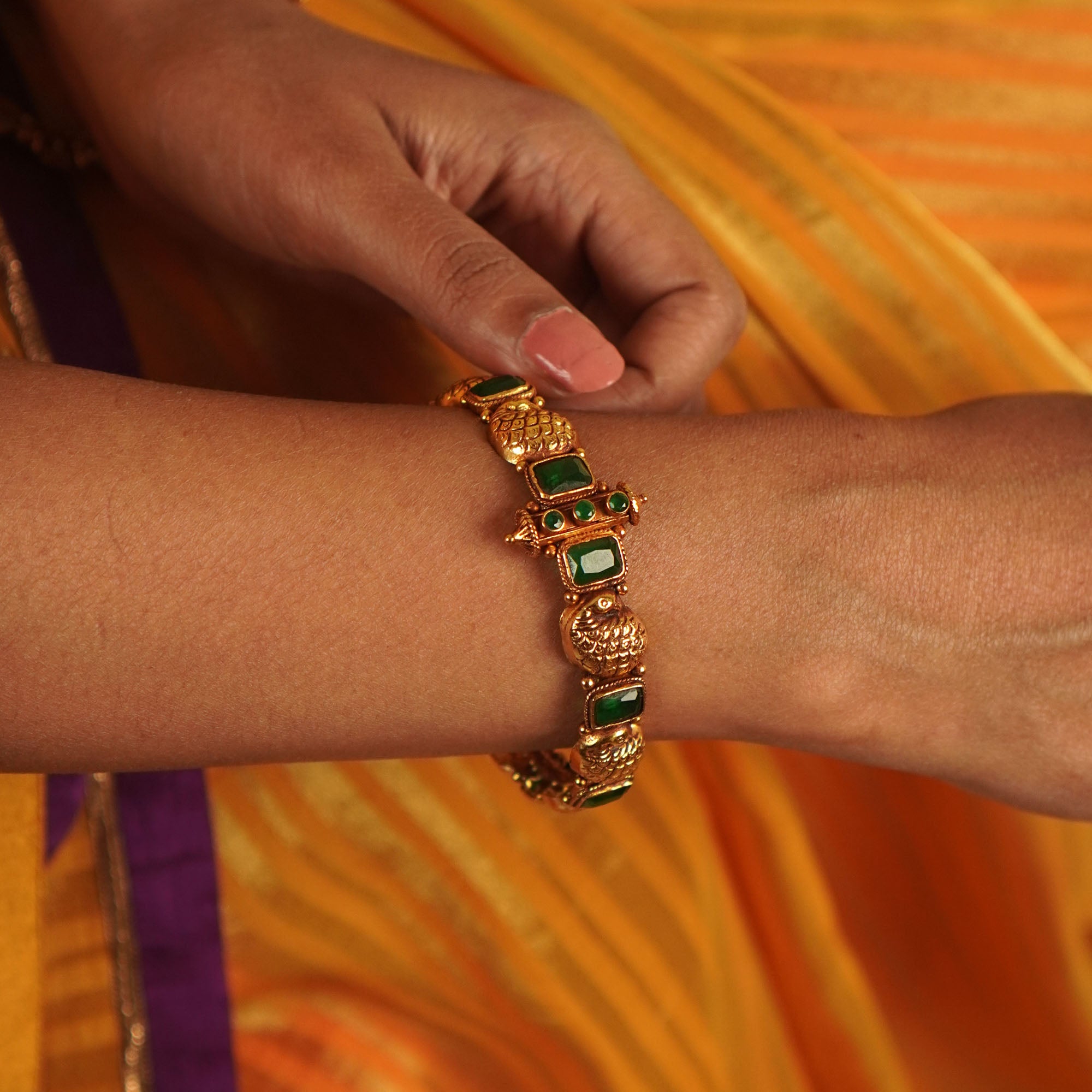 Sleek, handcrafted gold-plated silver bangle channel-set with brilliant-cut emerald green stones.
A stunning silhouette.