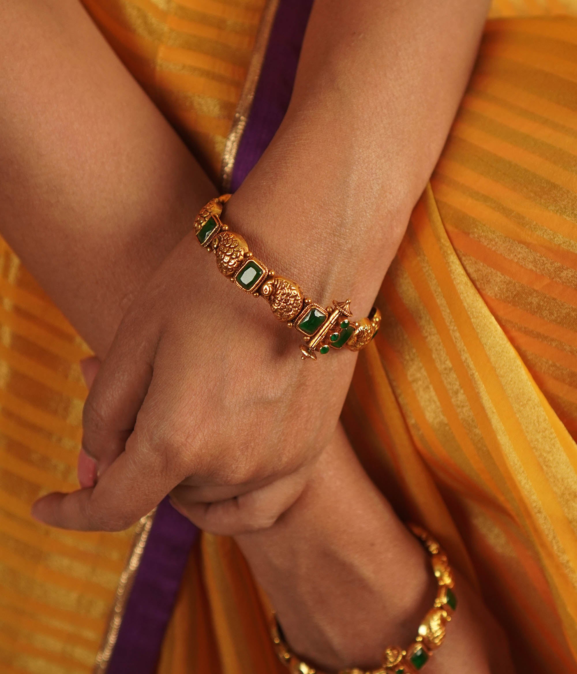 Sleek, handcrafted gold-plated silver bangle channel-set with brilliant-cut emerald green stones.
A stunning silhouette.