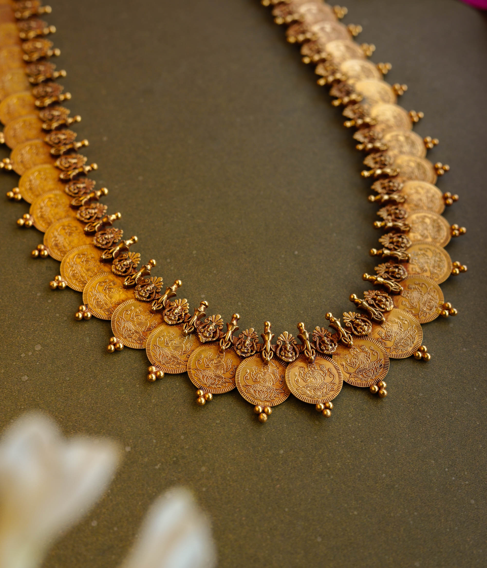 Antique gold temple necklace with dual-layer goddess coin motifs and intricate bead detailing.