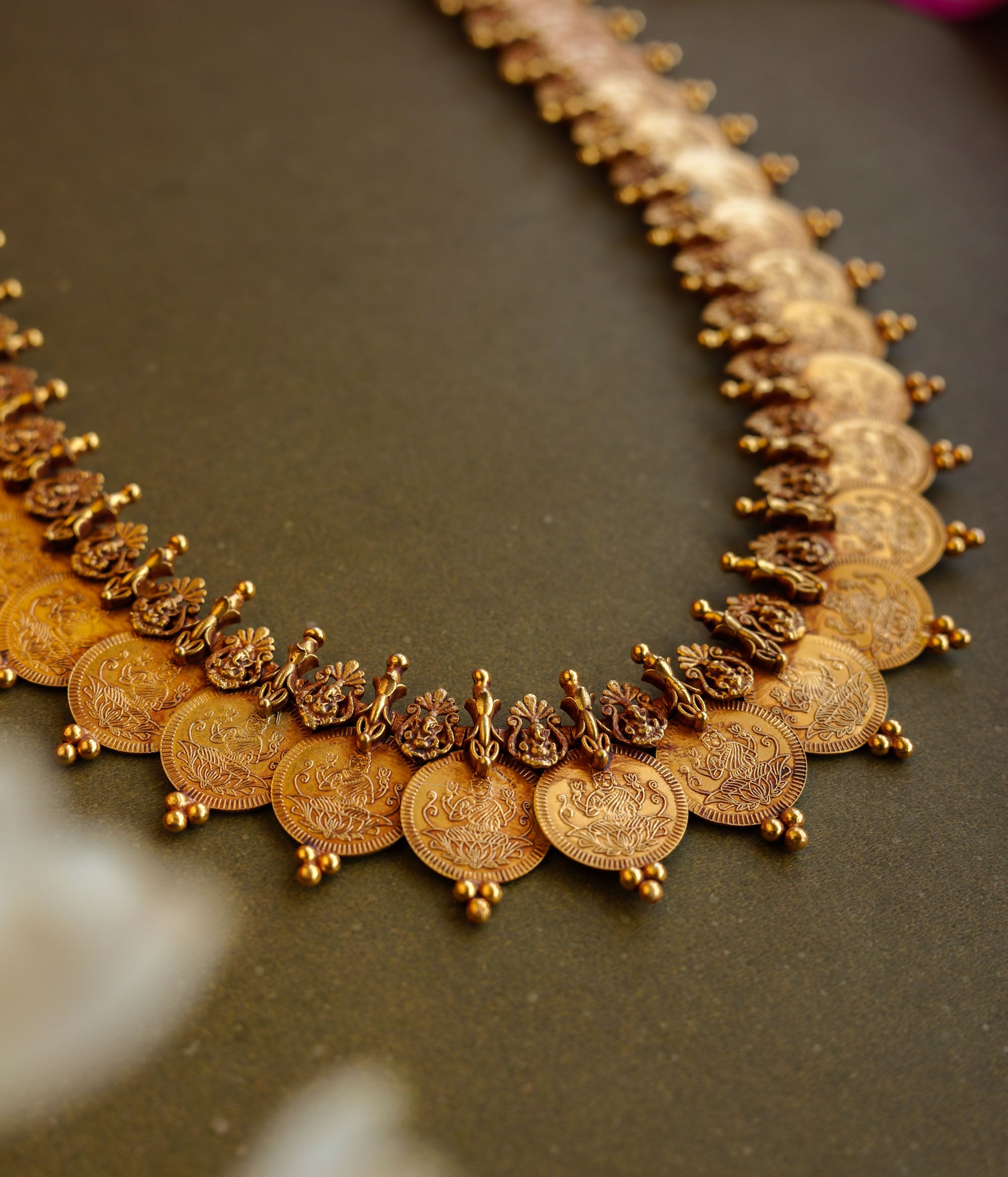 Antique gold temple necklace with dual-layer goddess coin motifs and intricate bead detailing.