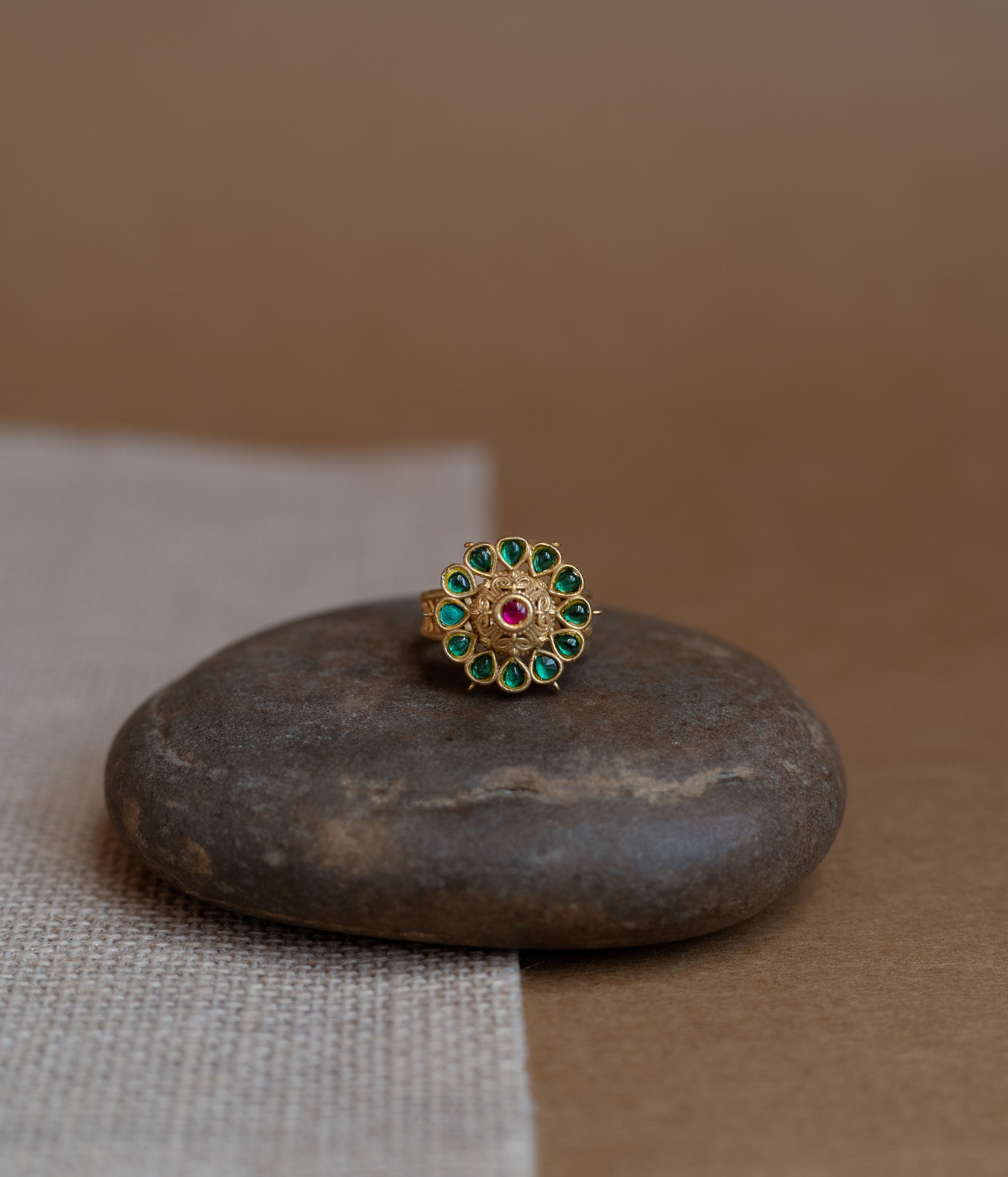 Temple collection ring with green Polki and red Spinal stones in traditional heritage design.