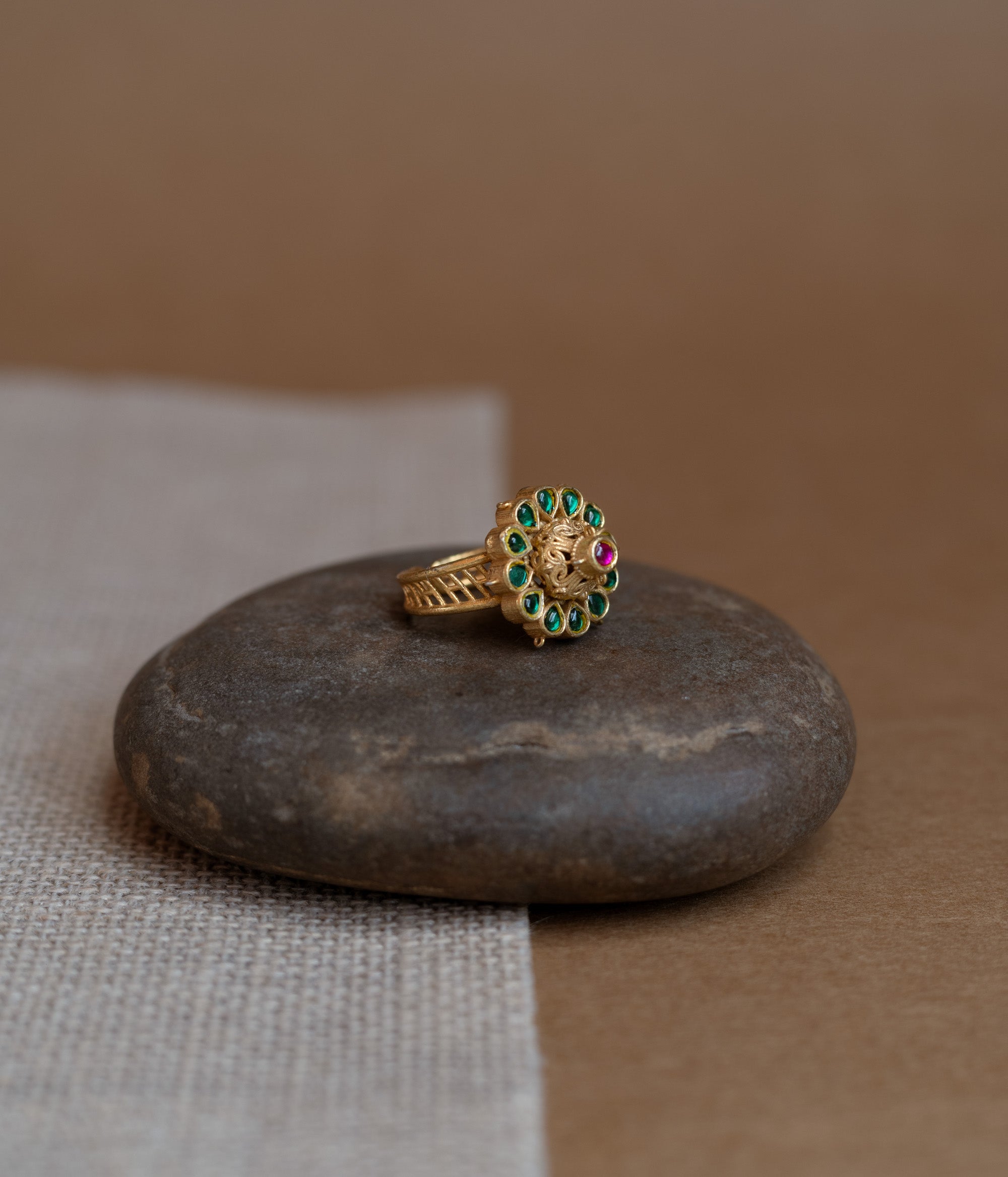 Temple collection ring with green Polki and red Spinal stones in traditional heritage design.