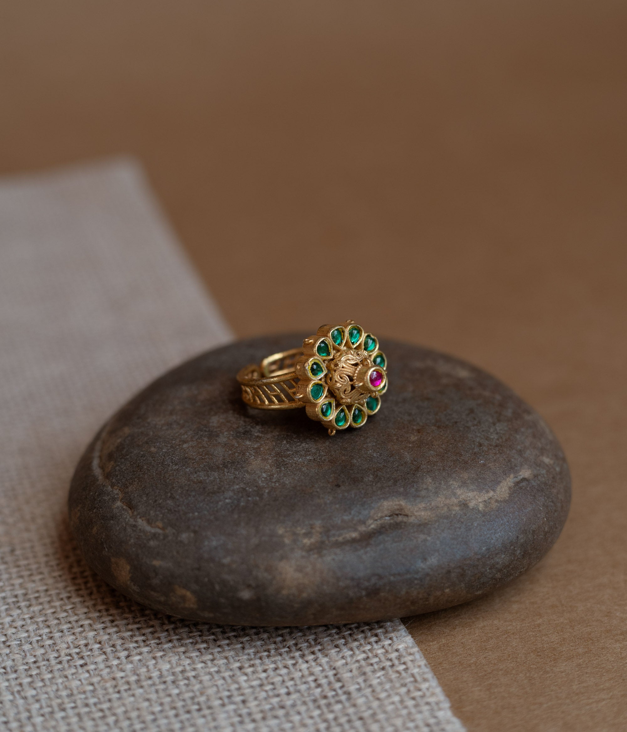 Temple collection ring with green Polki and red Spinal stones in traditional heritage design.