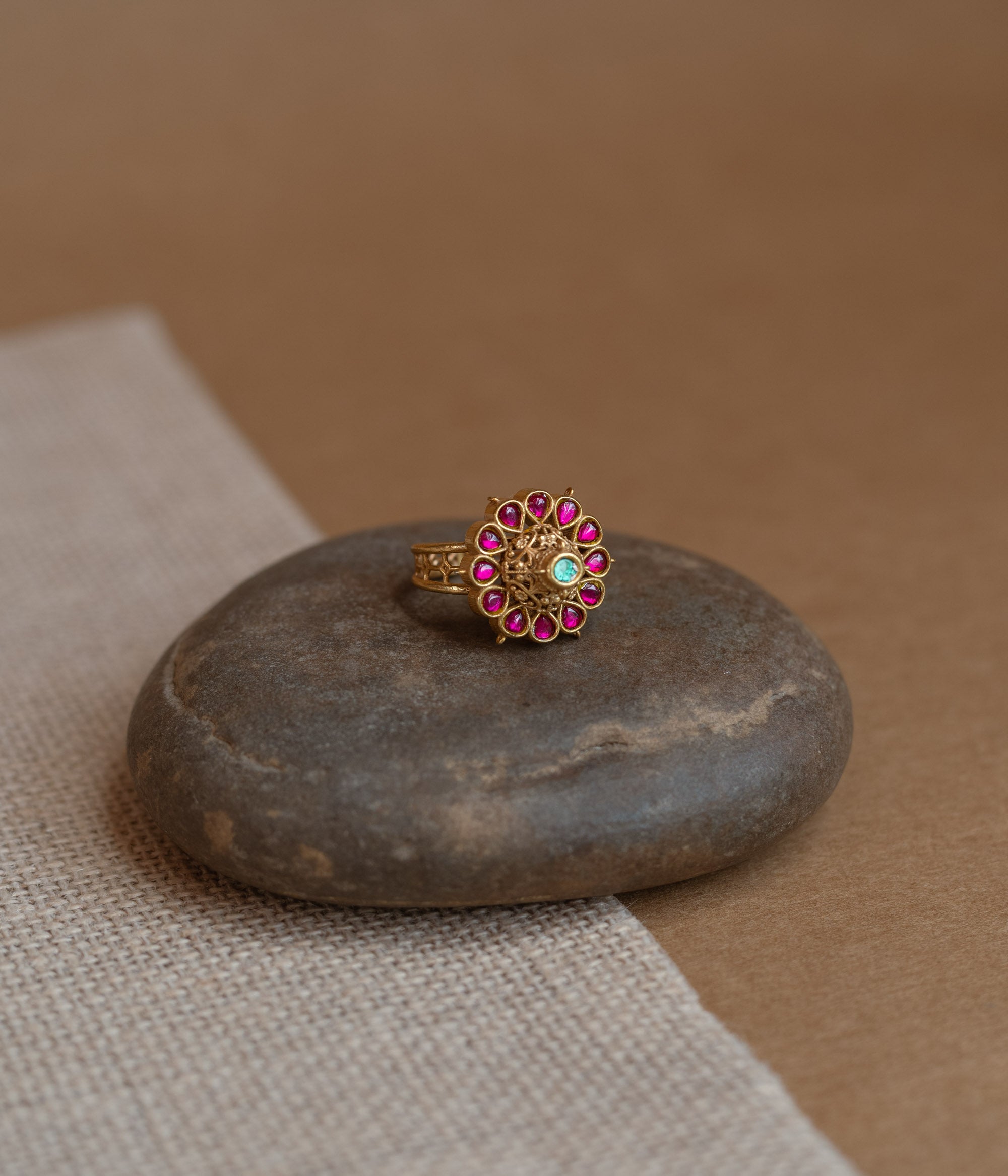 Temple ring with red Spinal and white Polki stones in traditional dual-tone design.
