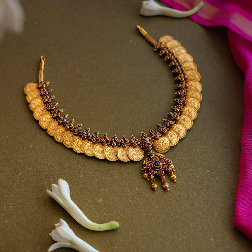 Gold coin motif necklace with red and green stones from Temple Collection.