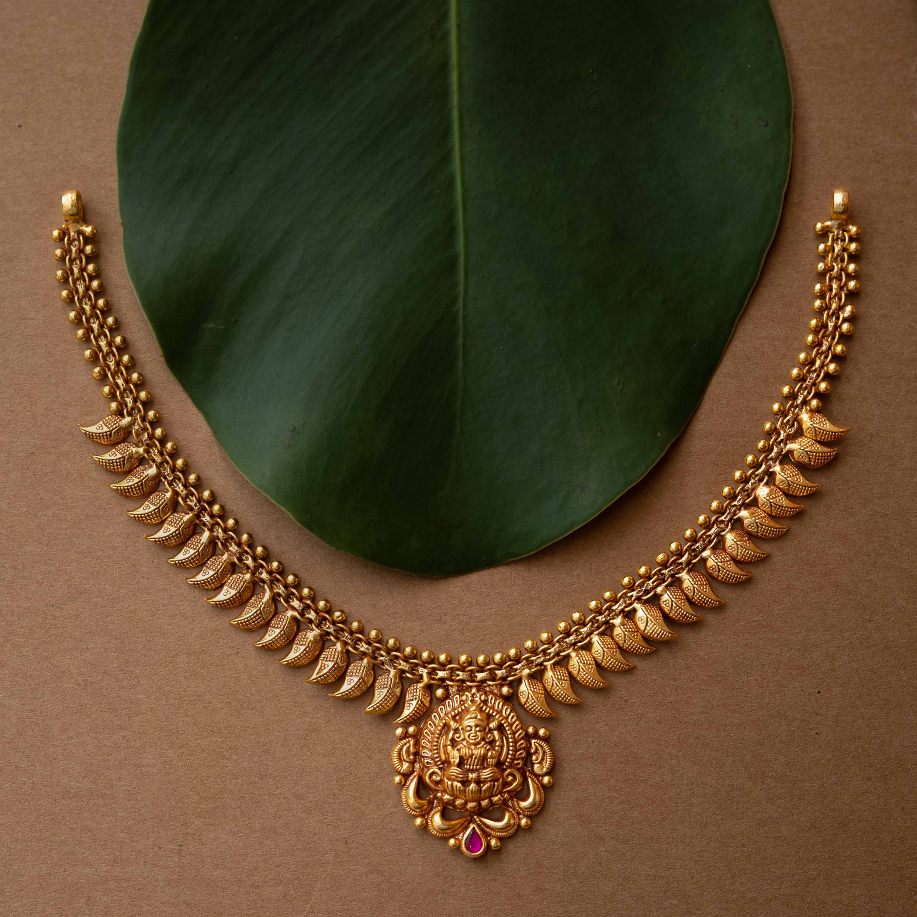 Antique gold necklace with Goddess Lakshmi pendant and crescent motifs from Temple Collection.