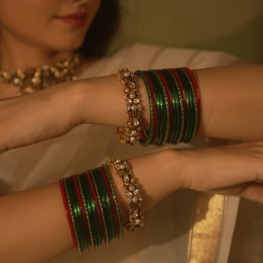 Golden temple bangle with peacock motif, Polki stones, and pearl detailing.