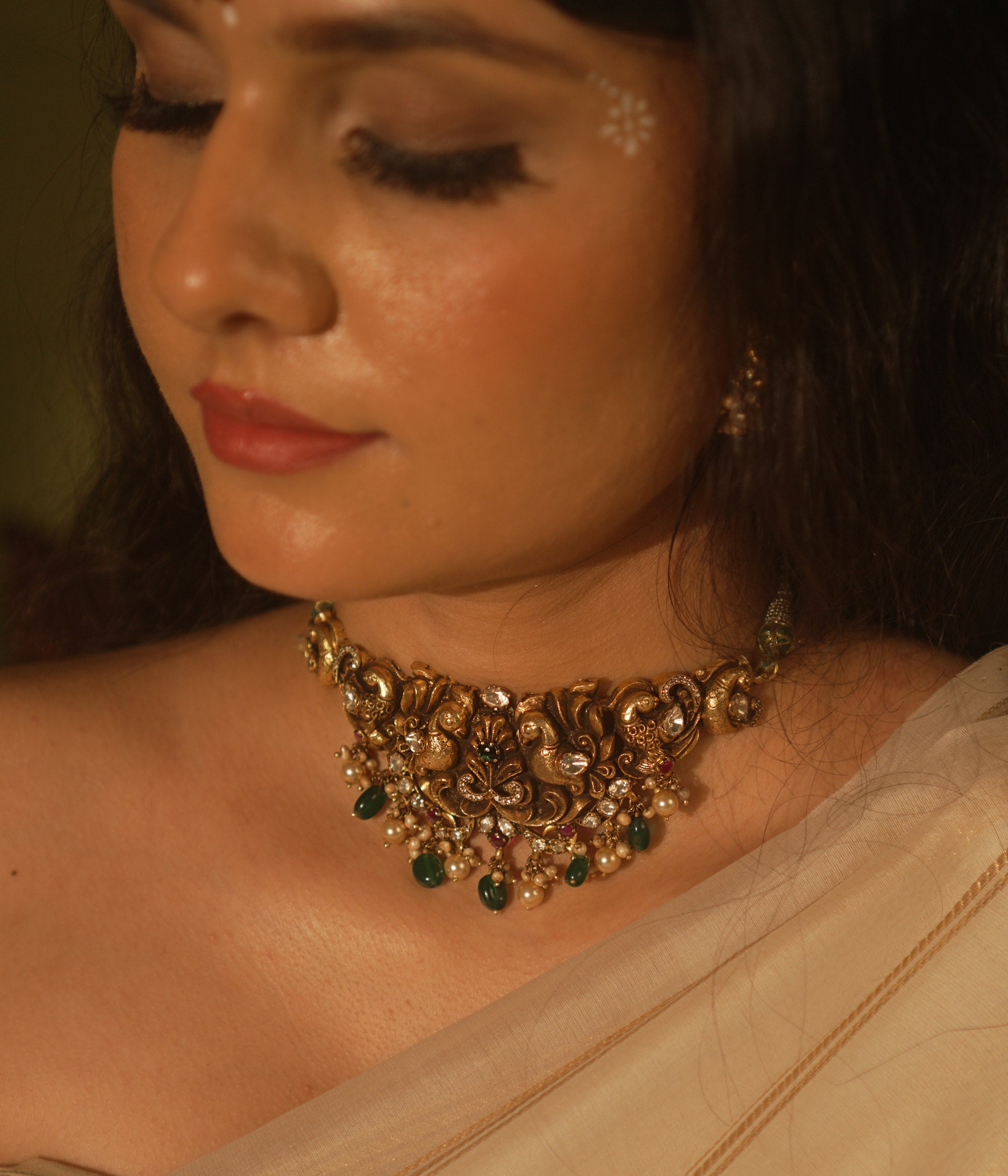 Temple collection choker with intricate peacock and floral carvings, adorned in Polki stones and pearls for ethnic elegance.
