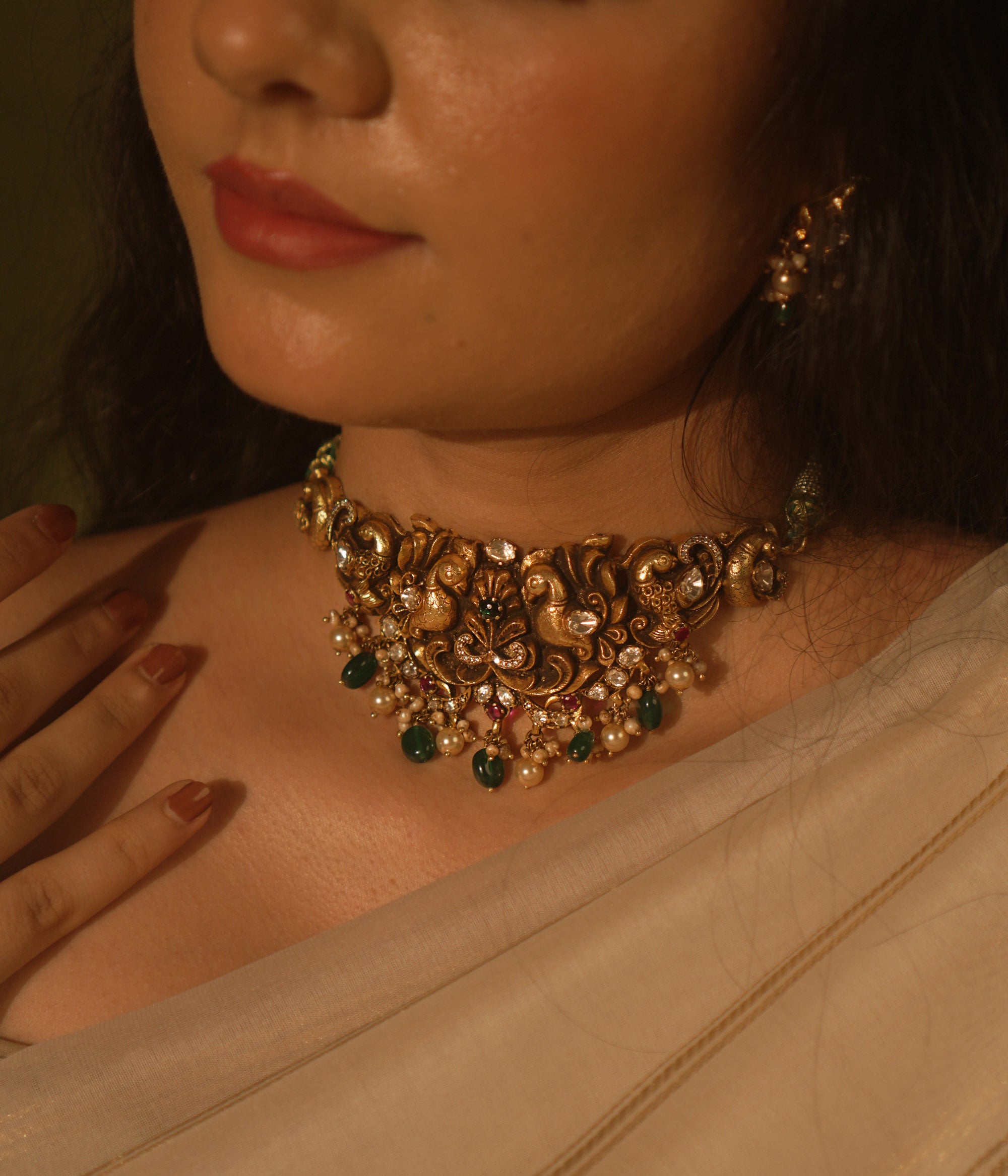 Temple collection choker with intricate peacock and floral carvings, adorned in Polki stones and pearls for ethnic elegance.