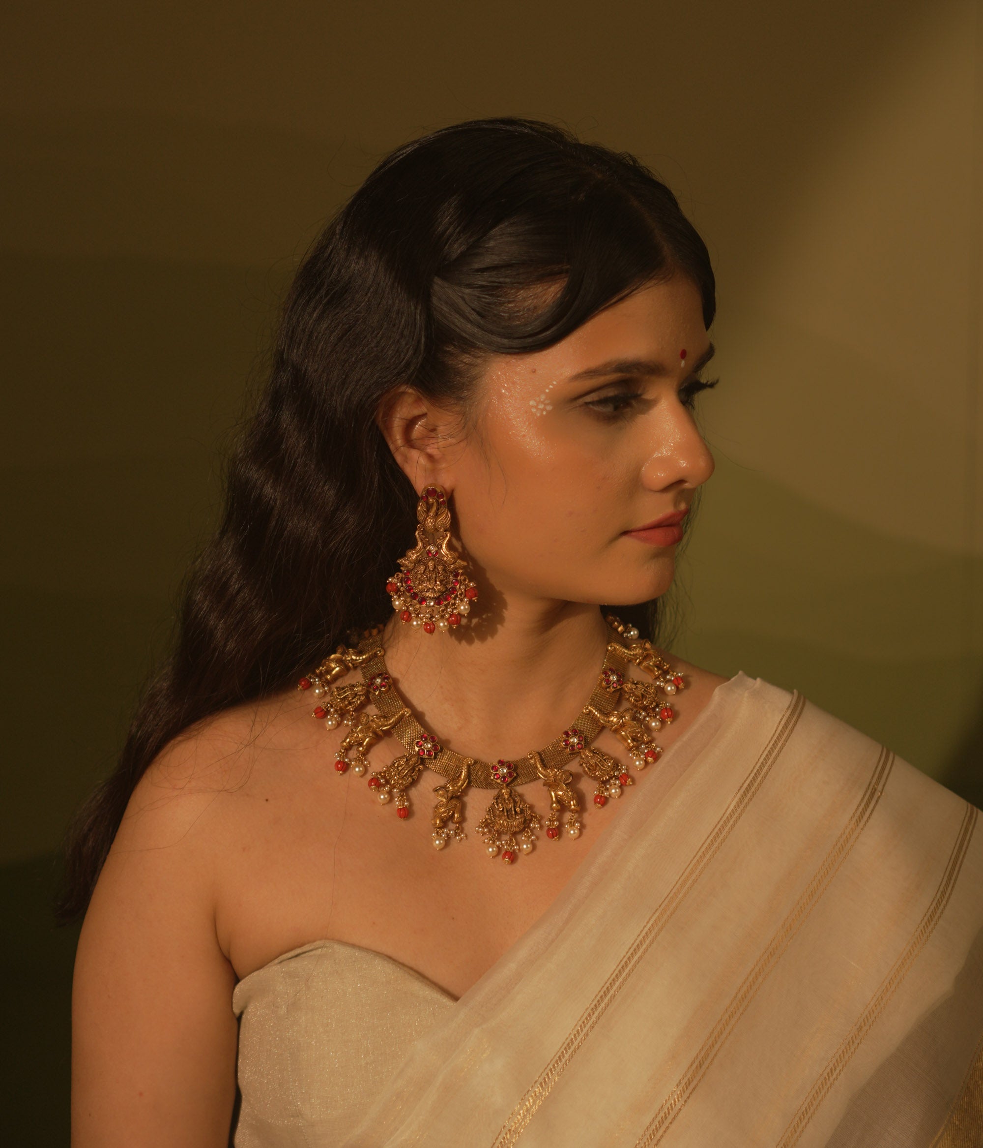 Temple collection Aamala Earrings with Goddess Lakshmi motif, elephants, pink Kundan stones, pearls, and coral beads.