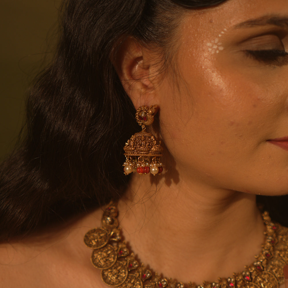 Temple collection Shyla Earrings featuring peacock motifs, Basra pearls, coral accents, and intricate Goddess Lakshmi-inspired jhumka design.