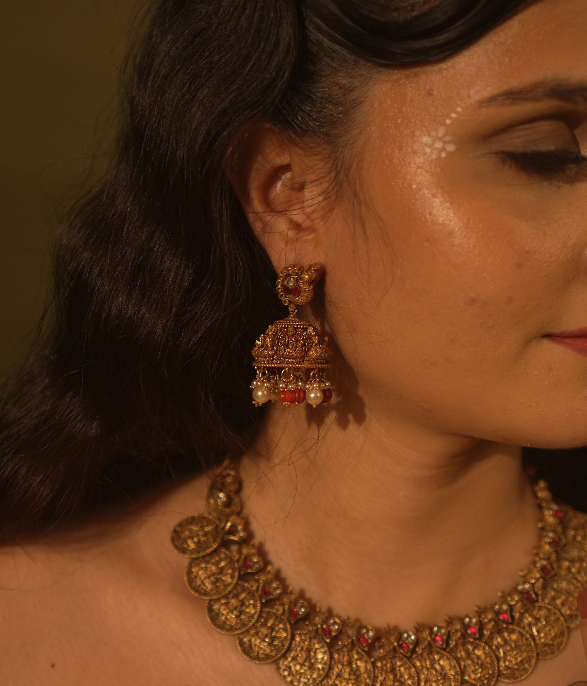 Temple collection Shyla Earrings featuring peacock motifs, Basra pearls, coral accents, and intricate Goddess Lakshmi-inspired jhumka design.