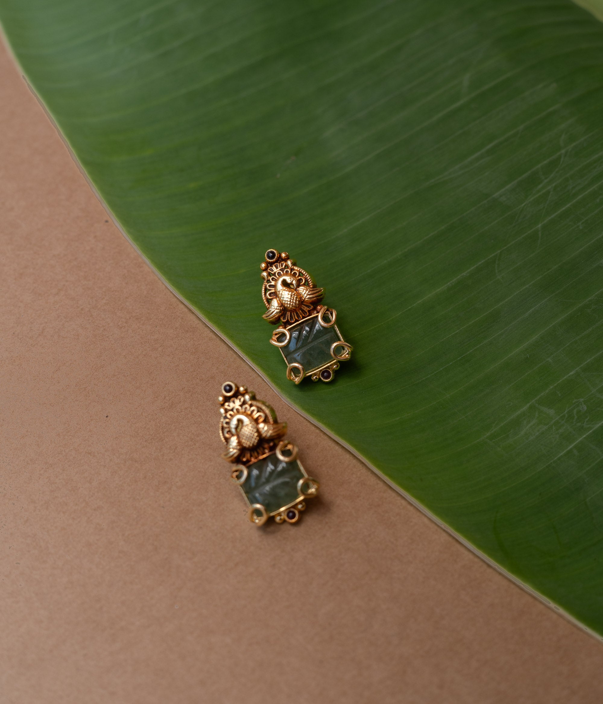 Temple-style gold earrings with peacock design and green onyx stone, from the Temple Collection.