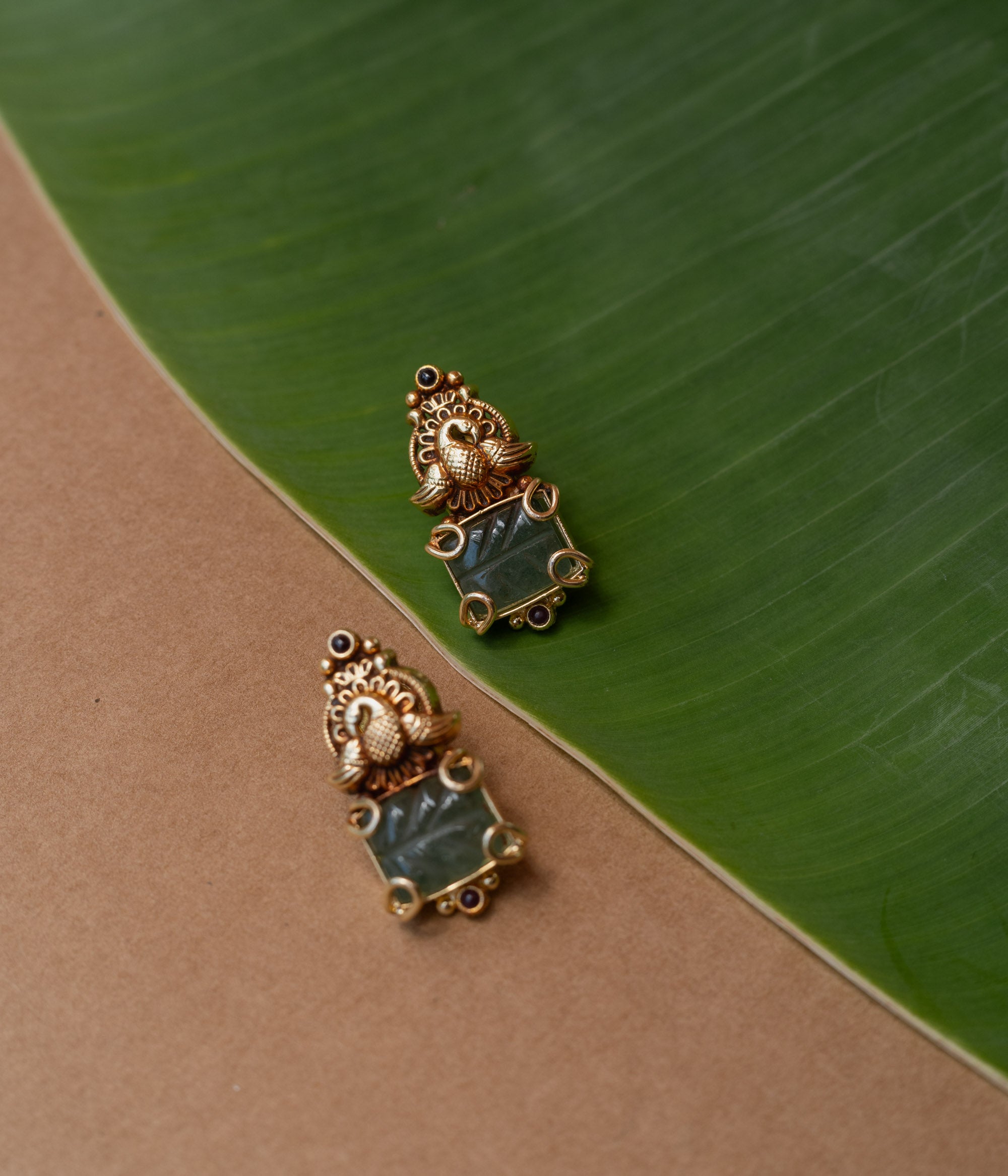 Temple-style gold earrings with peacock design and green onyx stone, from the Temple Collection.
