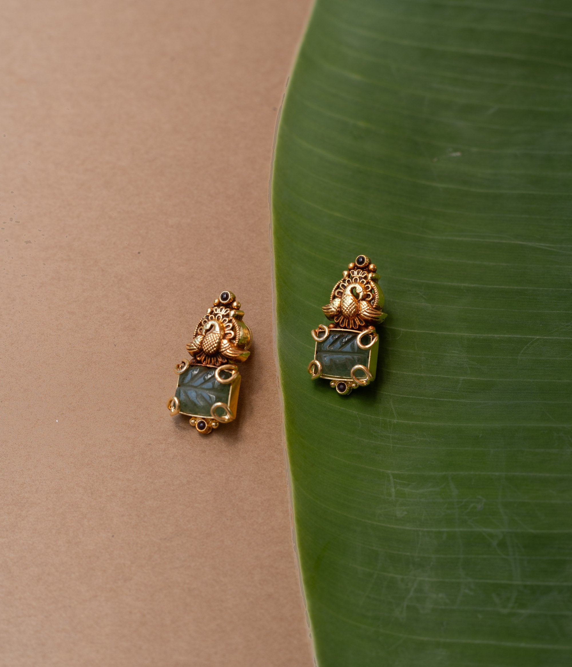 Temple-style gold earrings with peacock design and green onyx stone, from the Temple Collection.