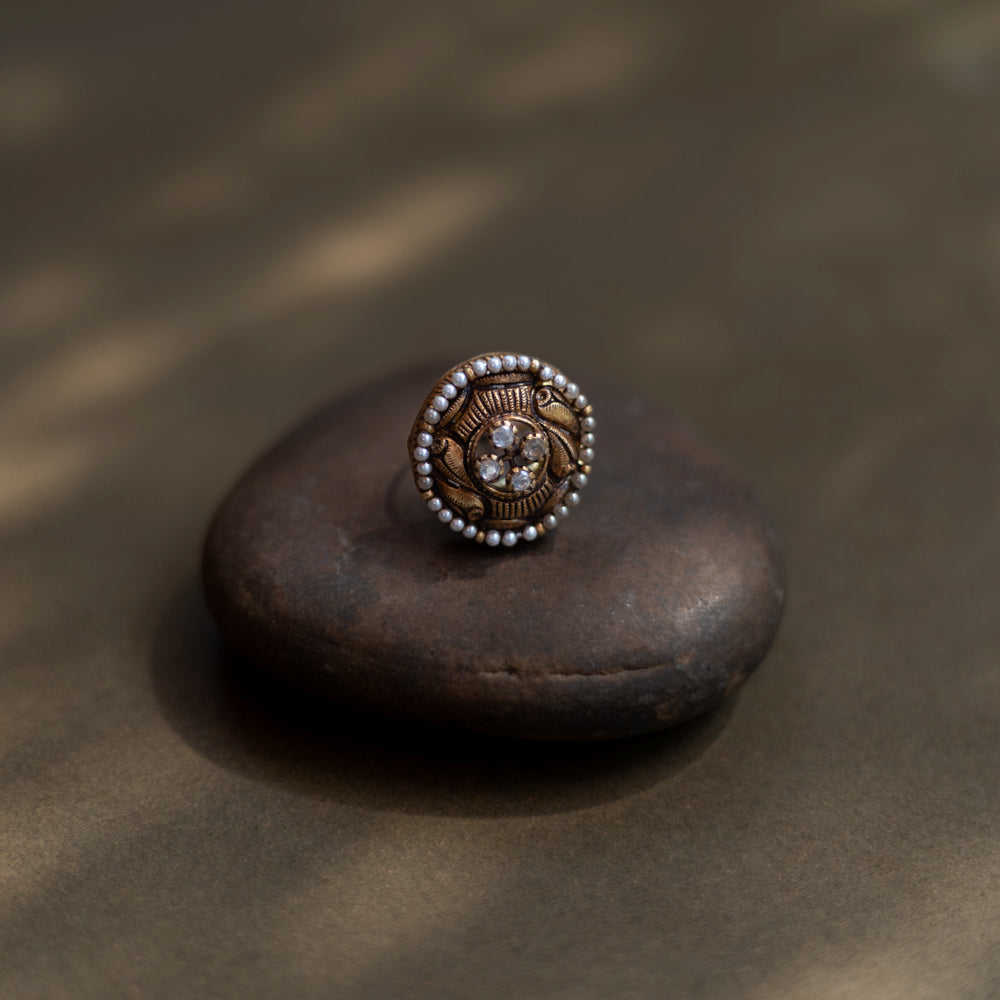 Heritage Glow Antique Ring: a mirror to ancient souls, encircled by golden carvings and a pearl halo. A tiny bird whispers tales of heritage on your finger.