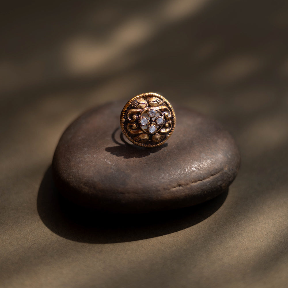 Antique gold-toned ring with ornate floral motif and radiant central mirror stones" is well-suited for the product description of the "Eternal Blossom Antique Ring."