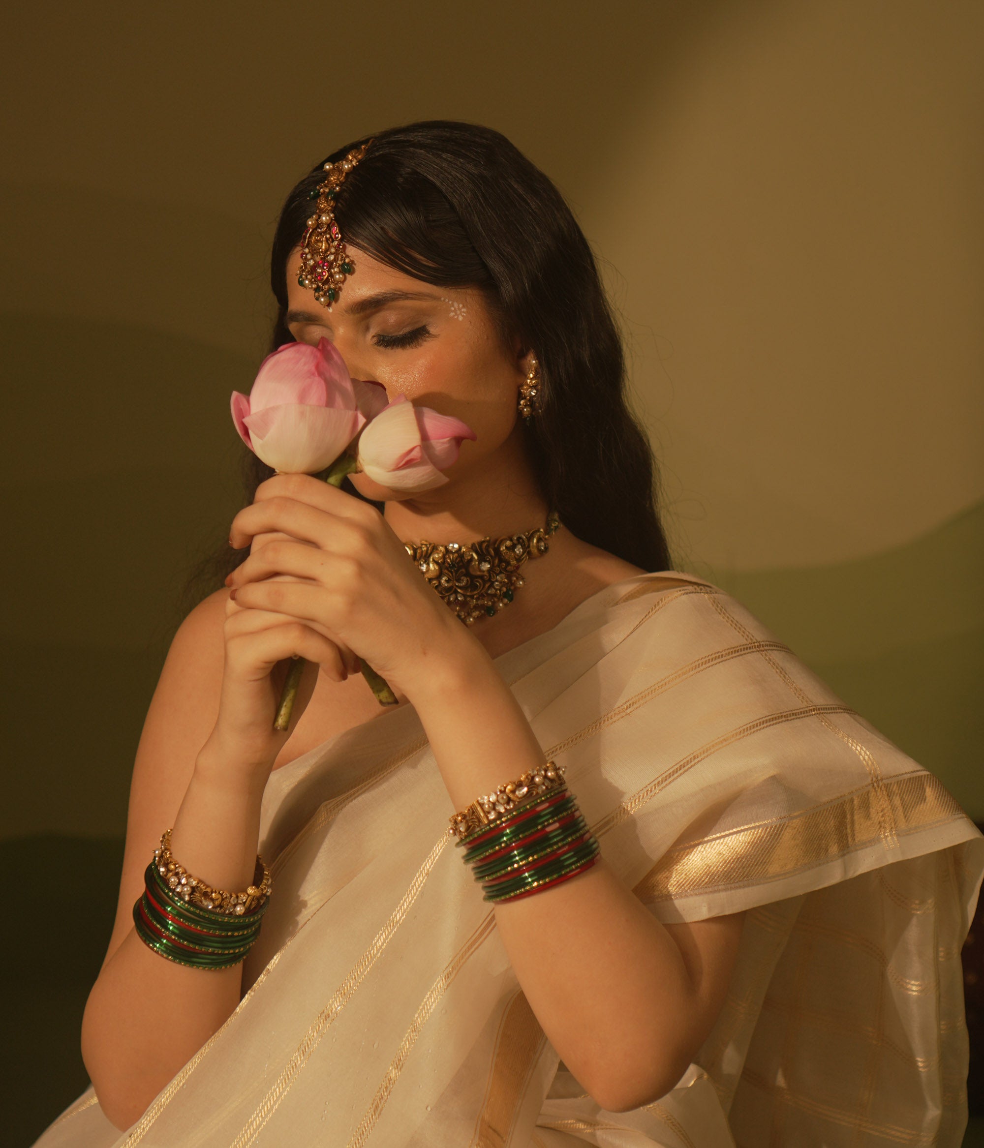 Temple collection maangtika featuring peacock and floral designs with Kundan stones, pearls, and emerald beads for traditional elegance.