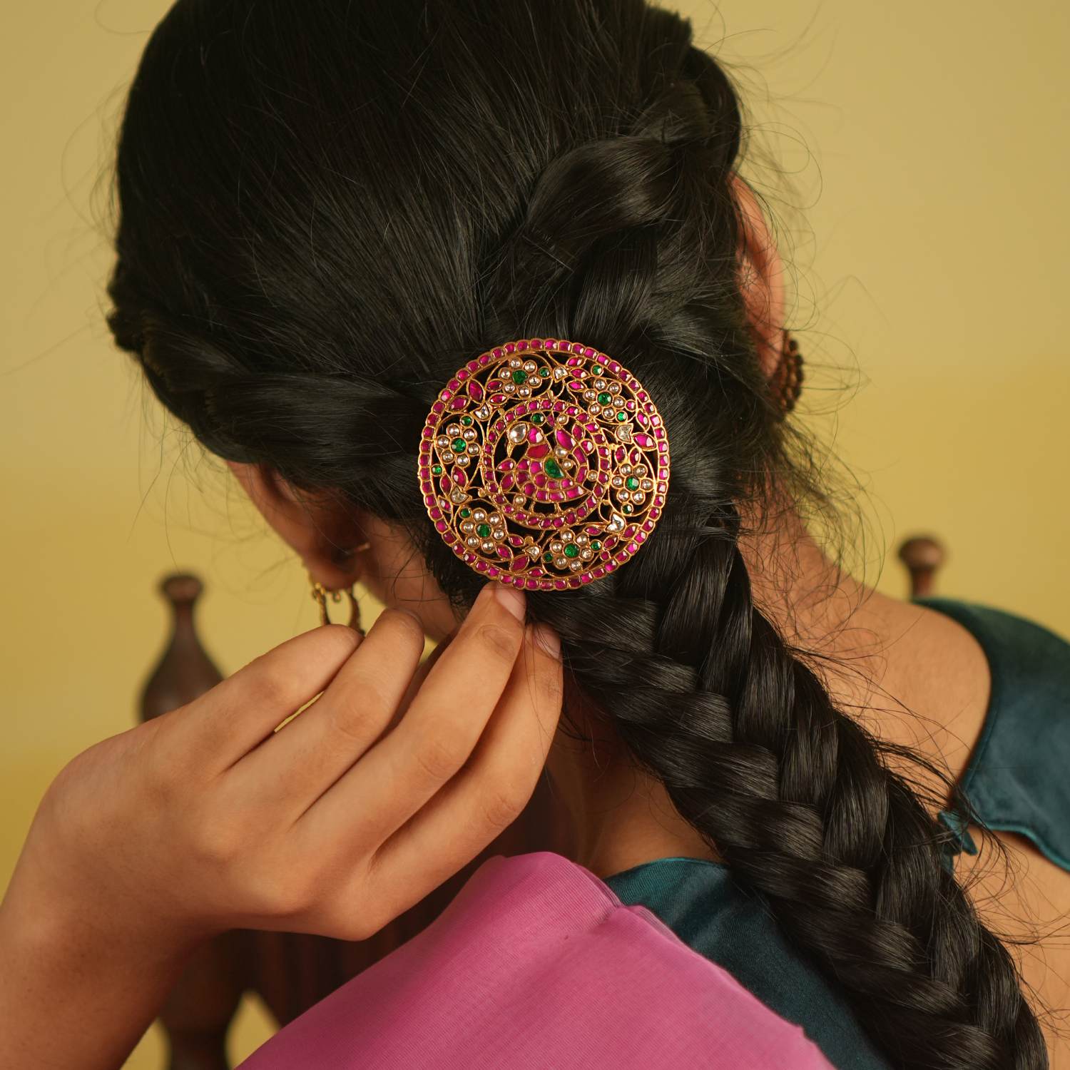 A hairpin adorned with red, green, and white Kundan stones, reflecting nature's brilliance—an ode to the peacock's grandeur and blossoming flowers.