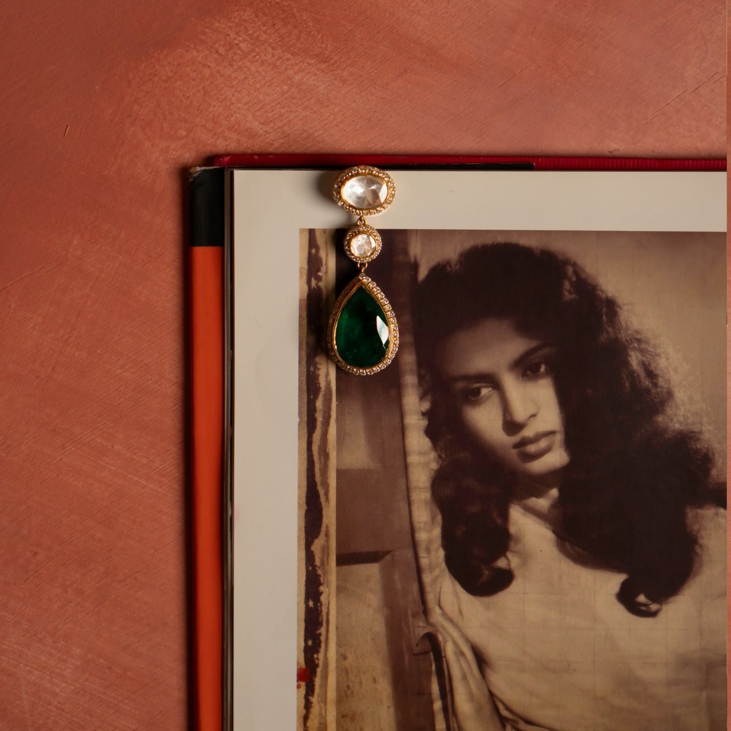 A beautifully crafted pendant, featuring an elegant design. The pendant showcases two dazzling Polki stones, delicately framed by shimmering CZ stones on both the top and bottom. Completing the look is a stunning drop made of a Green Doublet Stone, gracefully surrounded by CZ stones, adding a touch of sophistication. This exquisite piece blends timeless charm with modern elegance, making it a perfect statement accessory.