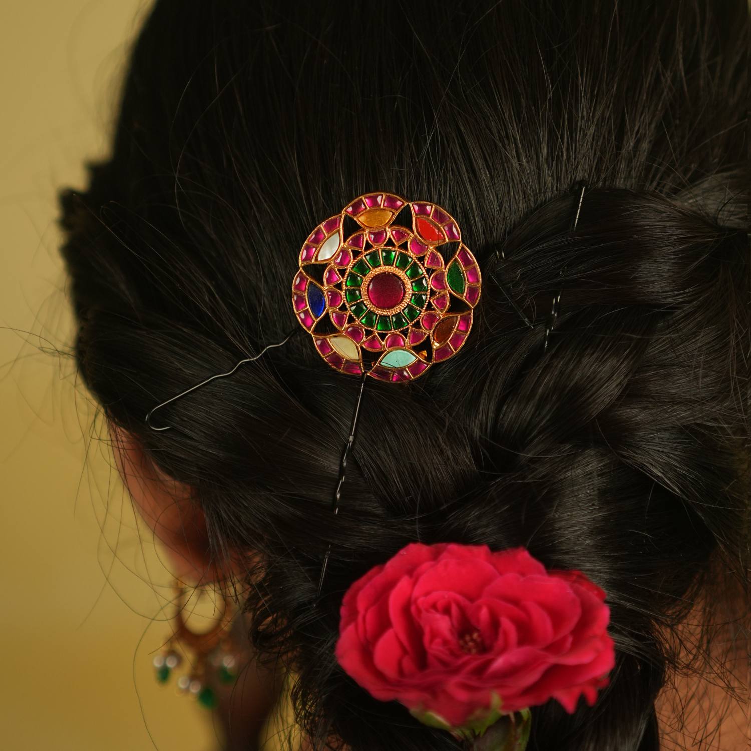 This round-shaped hairpin, adorned with red, white, and green Kundan stones, dazzles with its vibrant hues and intricate craftsmanship, making every moment enchanting.