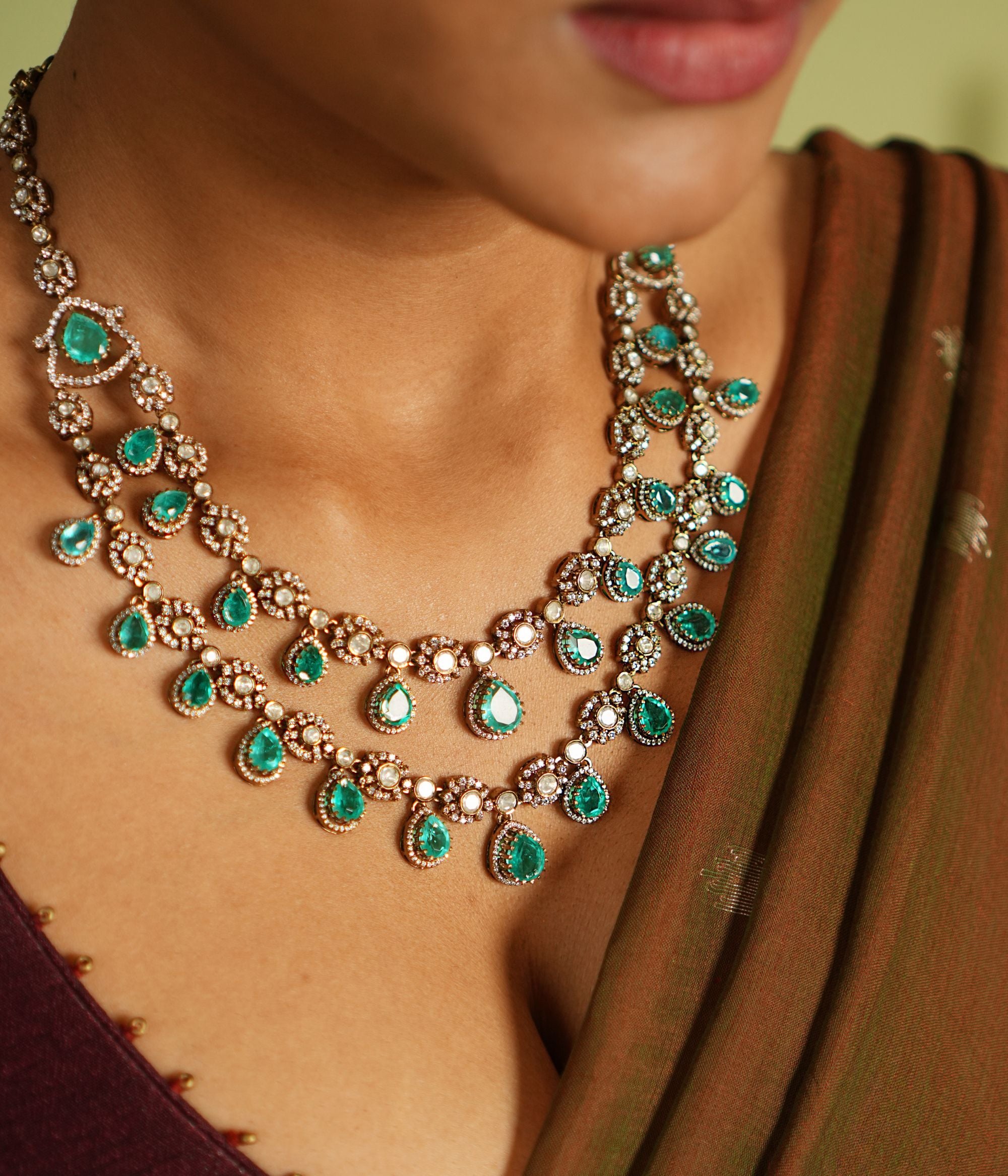 Exquisite two-layer gold-plated silver necklace adorned with moissanite Polki stones, CZ stones, and vibrant green gemstones, showcasing a timeless and sophisticated design perfect for any occasion.