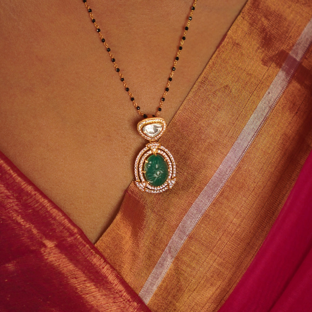 This drop pendant, featuring a striking emerald at its center encircled by a shimmering moissanite halo, is a lovingly handcrafted masterpiece. Celebrate the charm of artisanal imperfections.