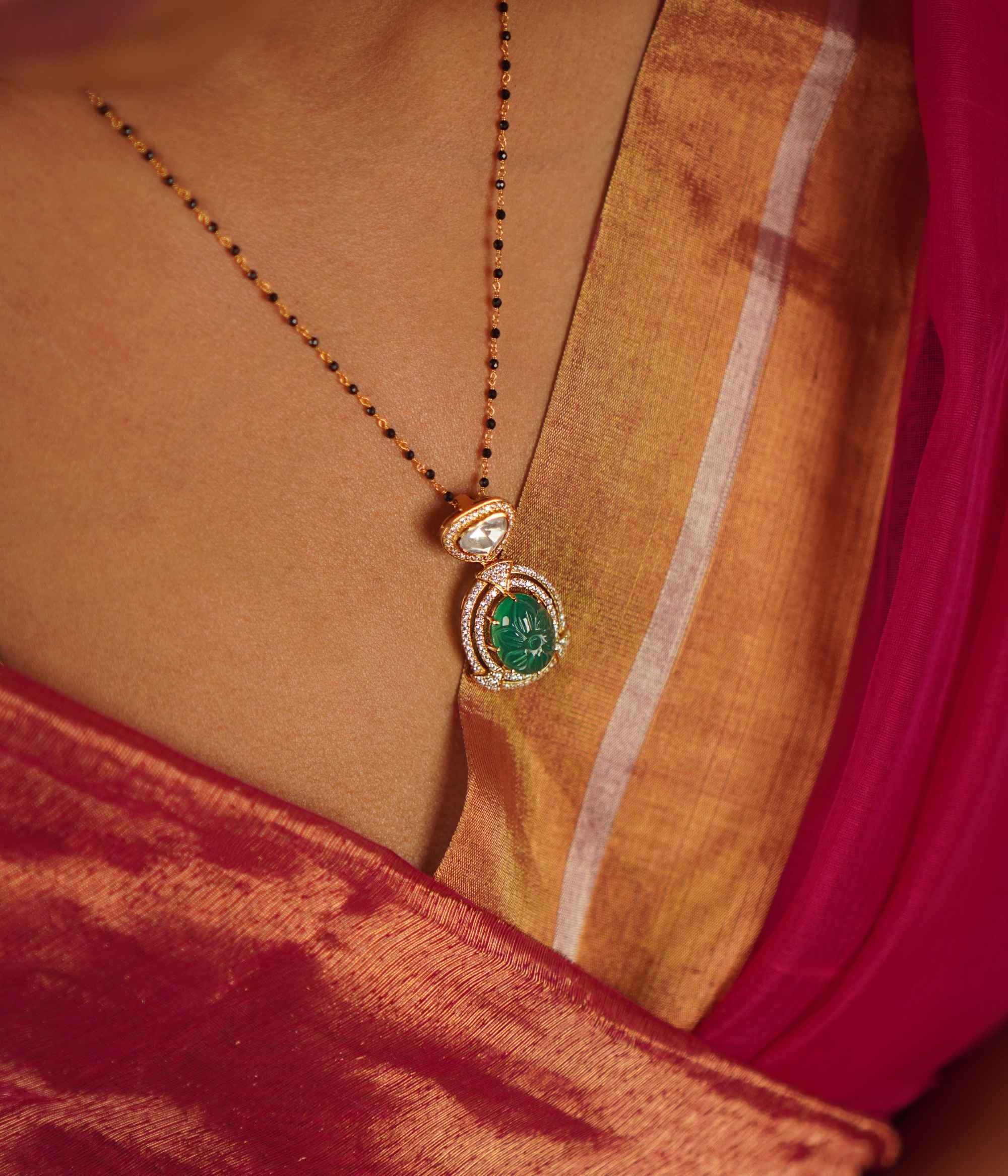 This drop pendant, featuring a striking emerald at its center encircled by a shimmering moissanite halo, is a lovingly handcrafted masterpiece. Celebrate the charm of artisanal imperfections.
