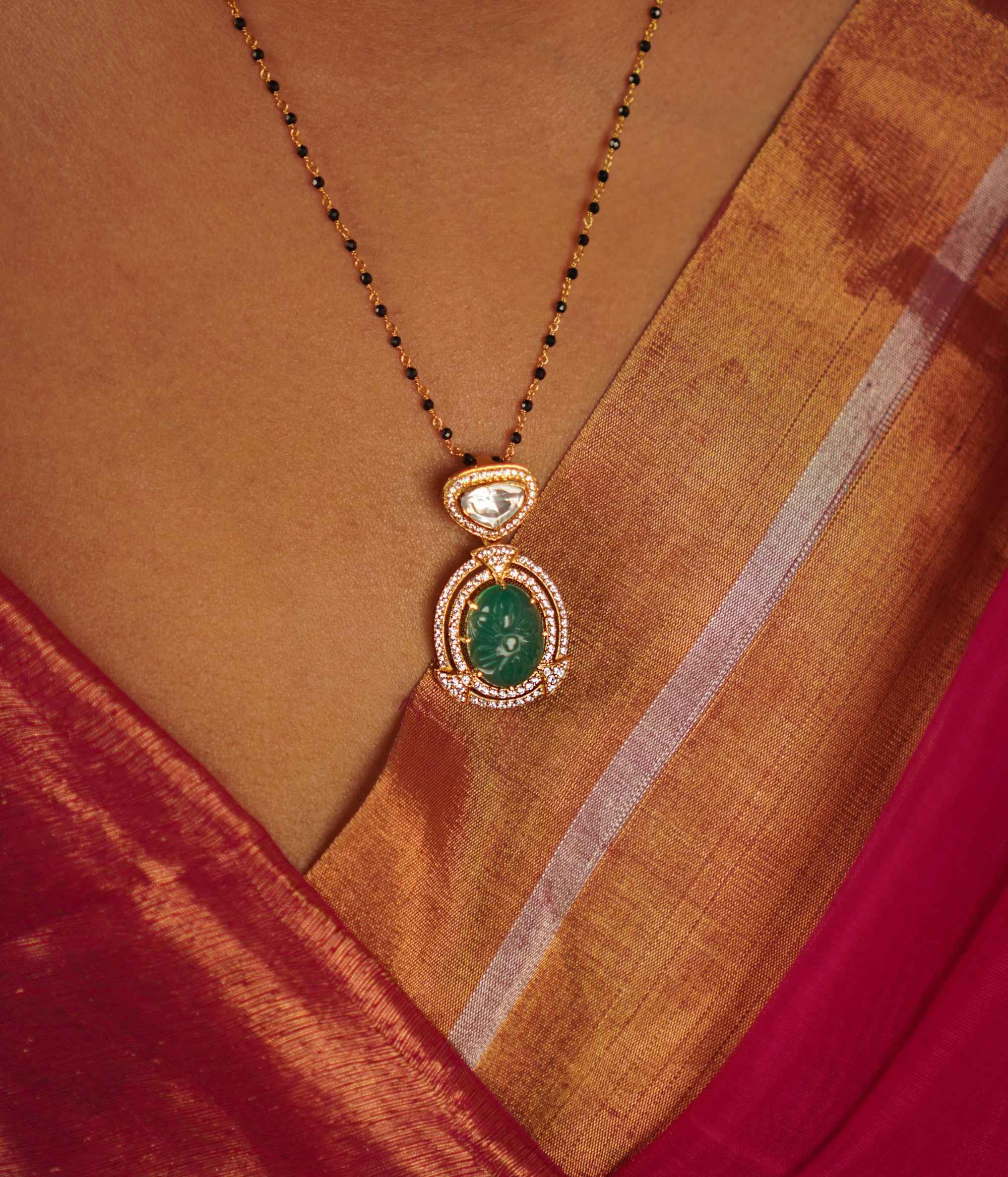 This drop pendant, featuring a striking emerald at its center encircled by a shimmering moissanite halo, is a lovingly handcrafted masterpiece. Celebrate the charm of artisanal imperfections.