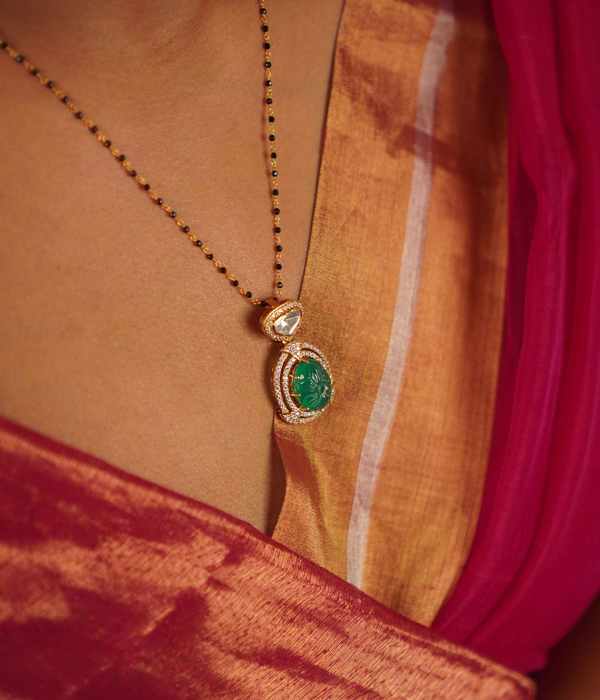 This drop pendant, featuring a striking emerald at its center encircled by a shimmering moissanite halo, is a lovingly handcrafted masterpiece. Celebrate the charm of artisanal imperfections.