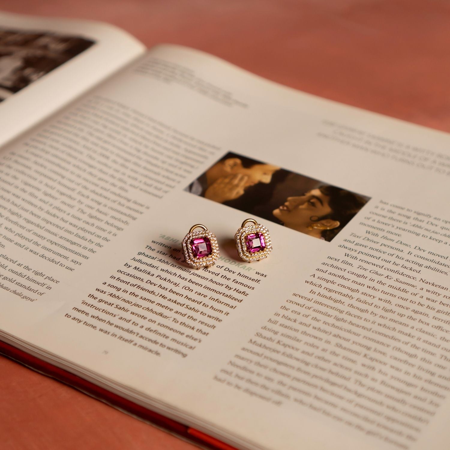 A stunning gold-plated silver stud earring in a classic square shape, featuring a vibrant pink tourmaline stone at its center. The design is elegantly framed by two layers of shimmering CZ stones, adding brilliance and sophistication. This exquisite piece exudes timeless elegance, making it a perfect accessory for any occasion.